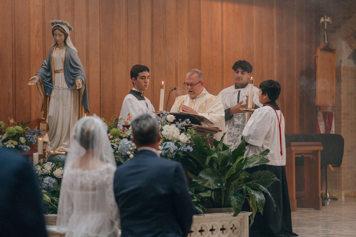 Couple kneeling at the shrine of Our Lady during the wedding Mass