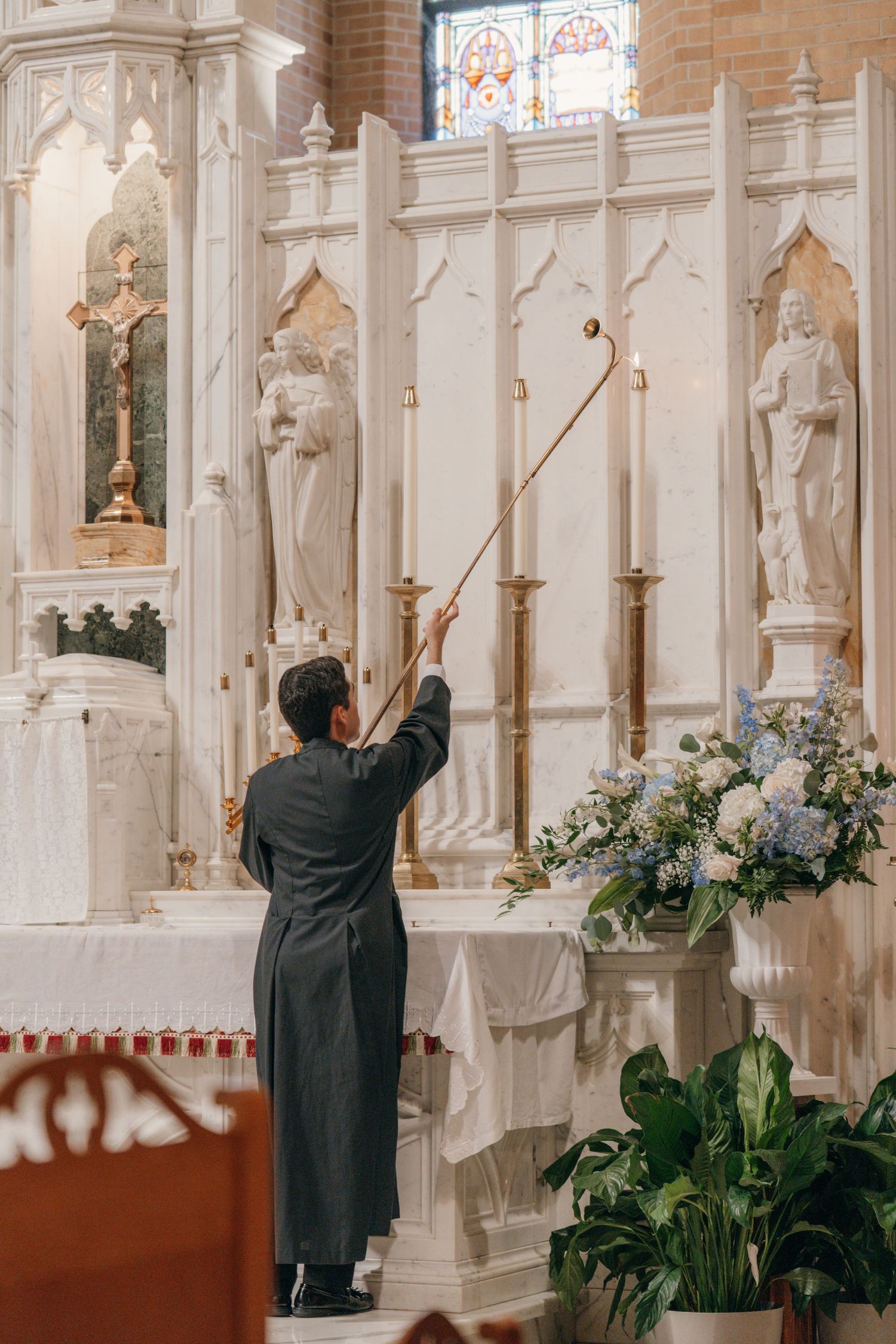 Sacristan lighting the altar candles before a Catholic wedding