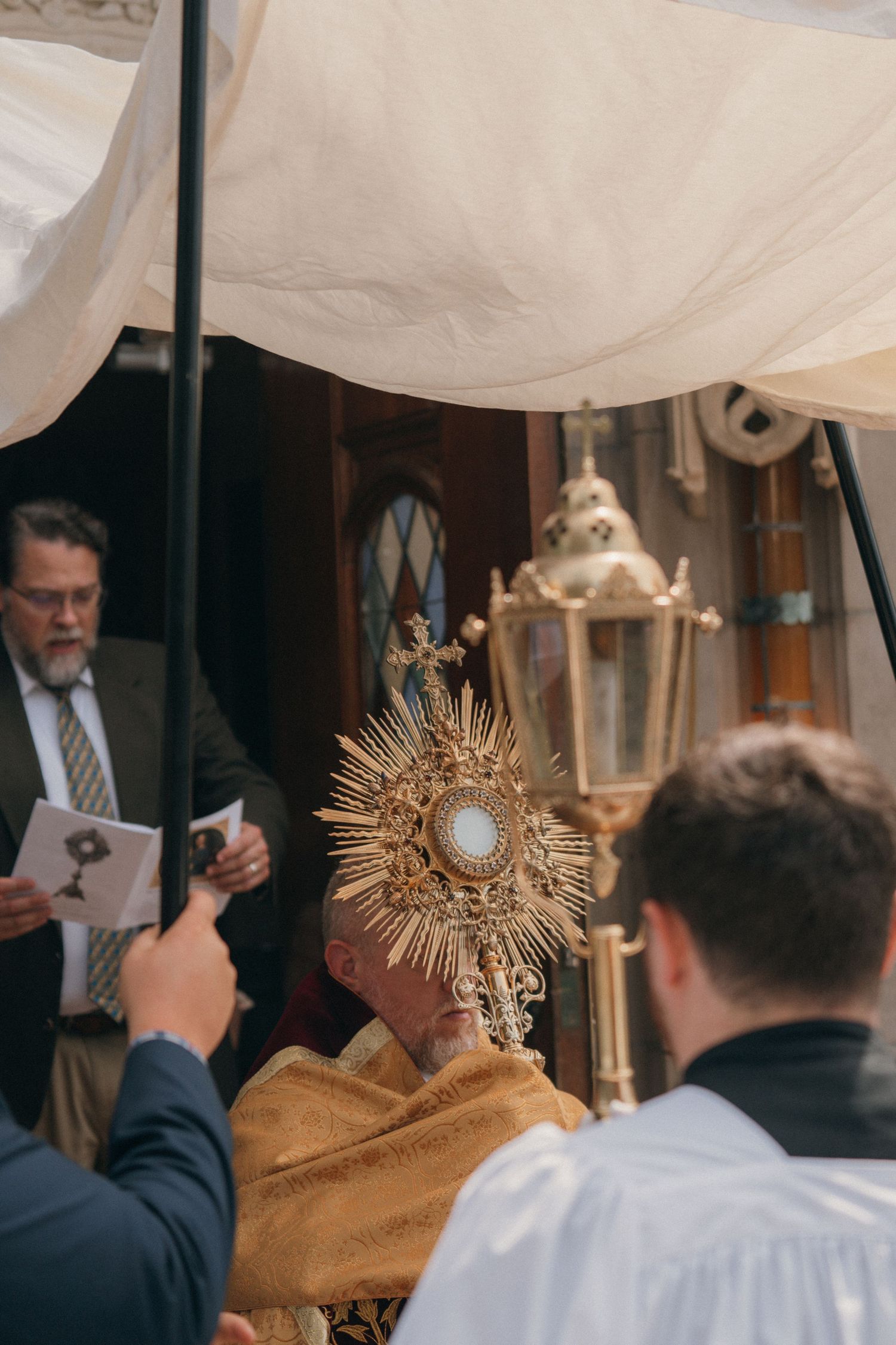 Monstrance and processional lantern under the canopy at the entrance of a stone church