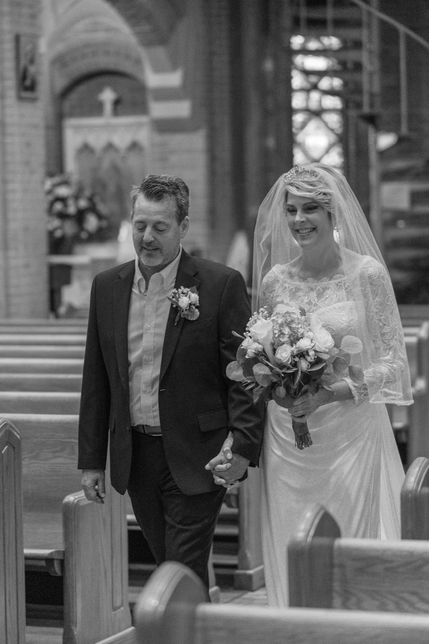 Black and white photo of the father walking the bride down the aisle