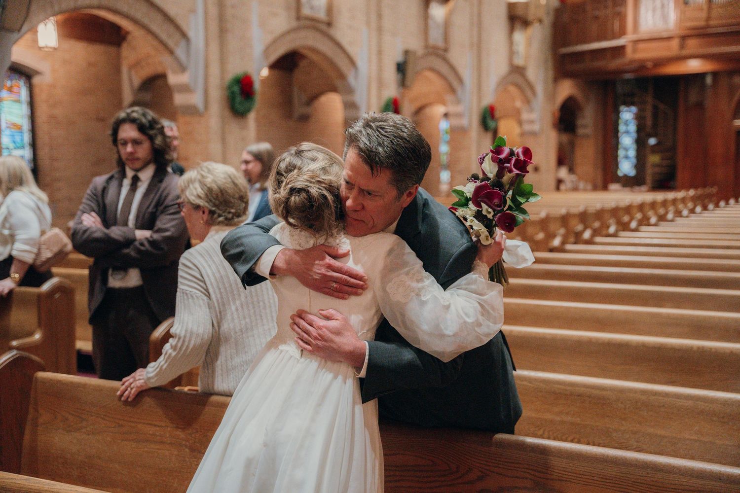 Bride hugging a guest in the church pews after the ceremony