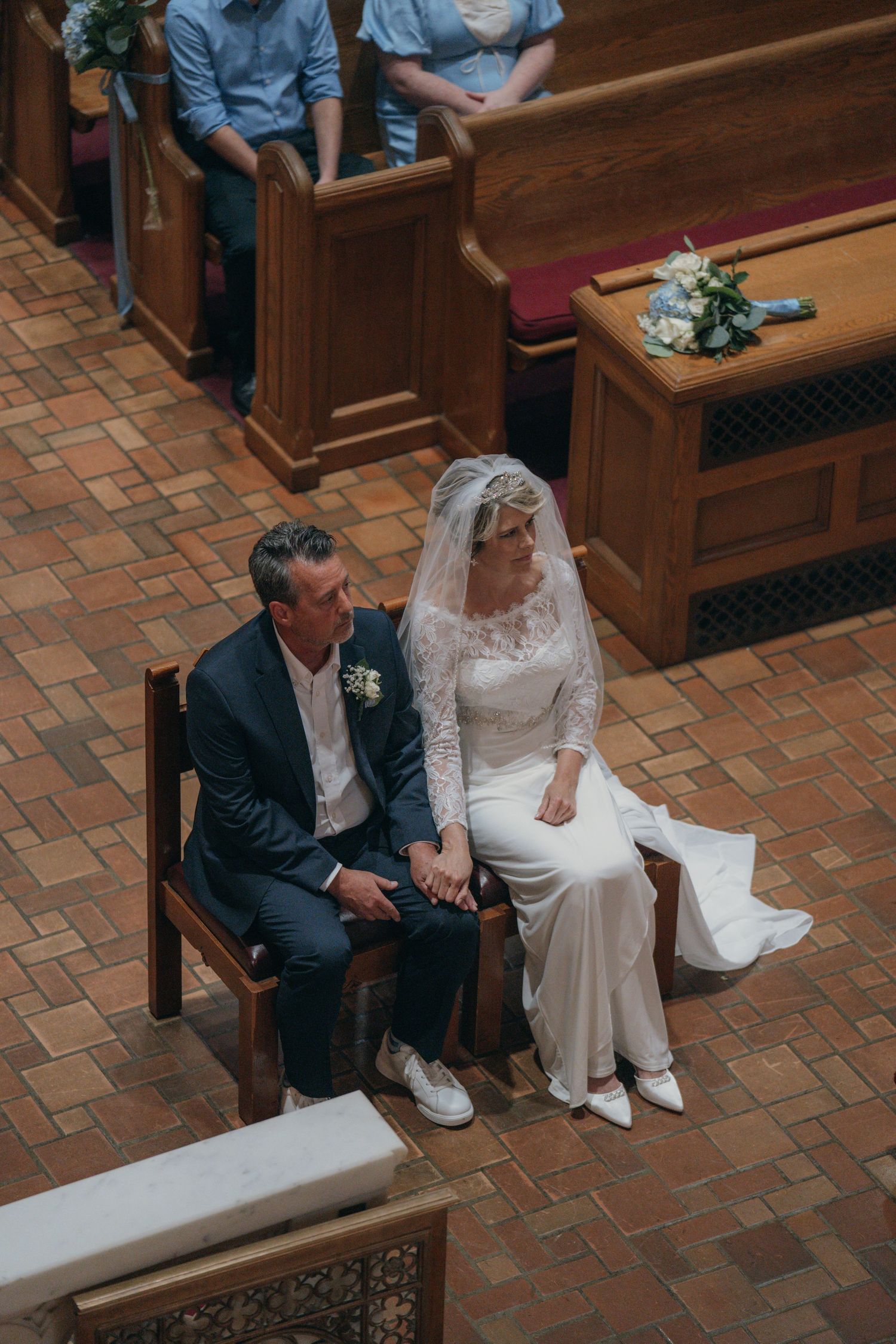 Bride and groom seated in the sanctuary during their Catholic wedding