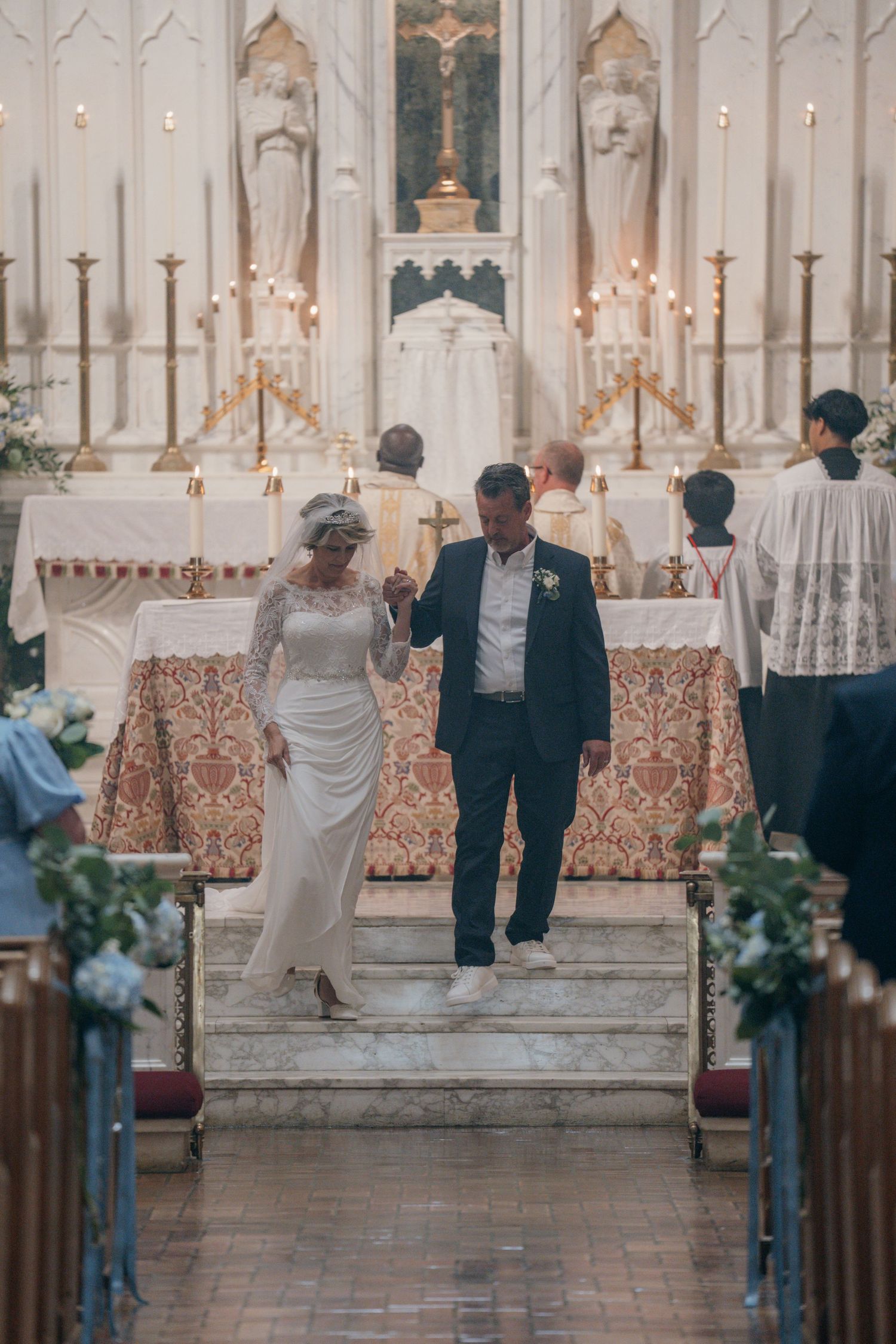 Newlyweds walking down the altar steps after their Catholic wedding