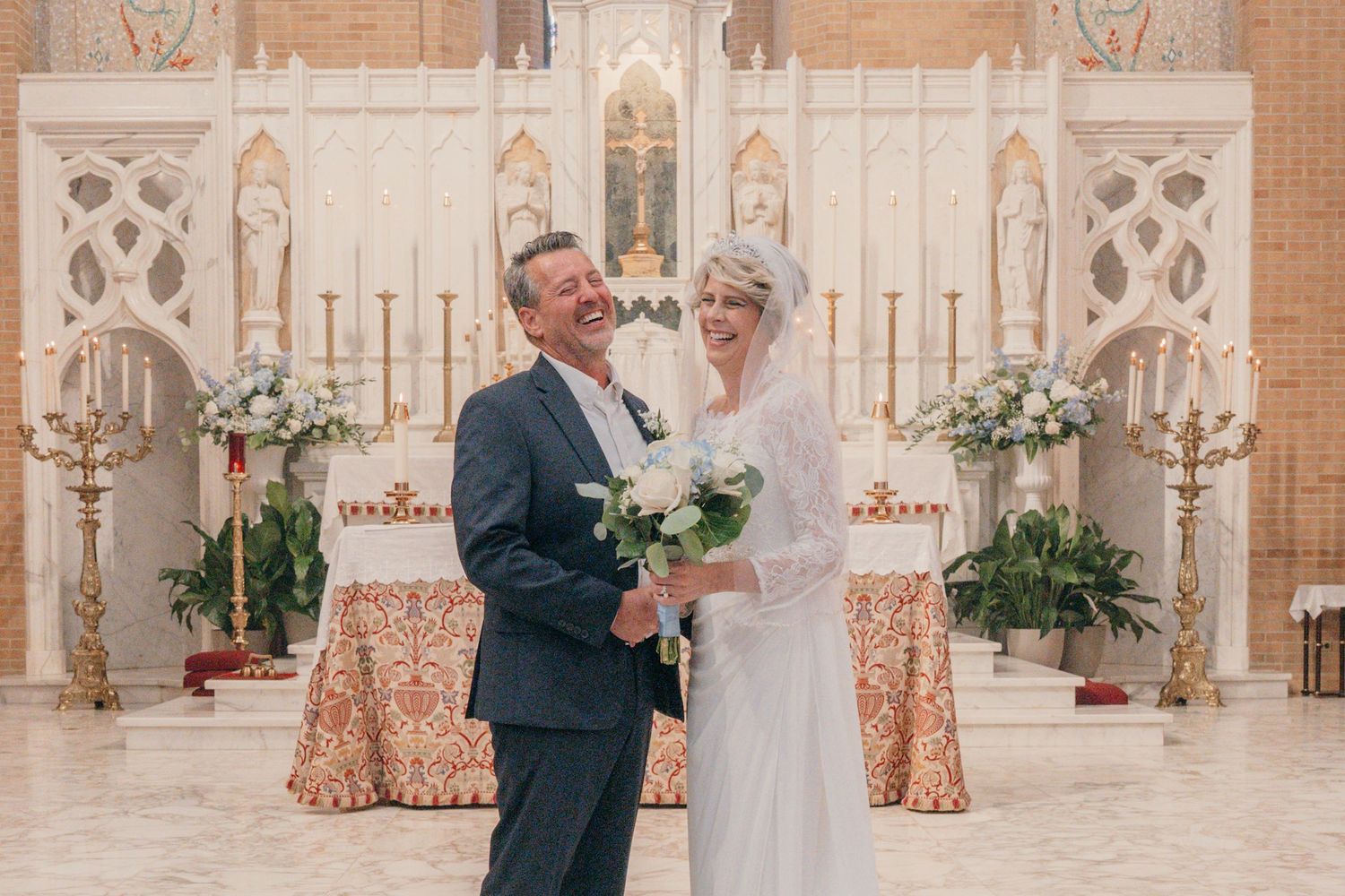 Bride and groom smiling at the altar of a Catholic church