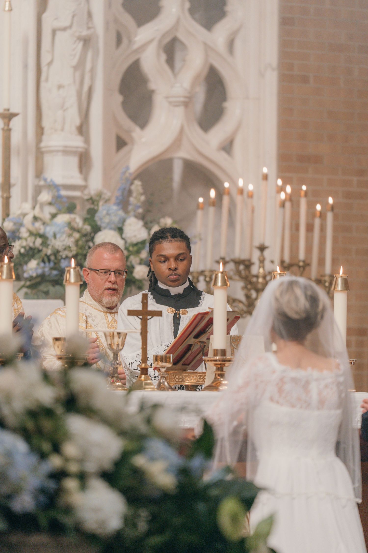 Priest and deacon at the altar facing the bride during a Catholic wedding Mass