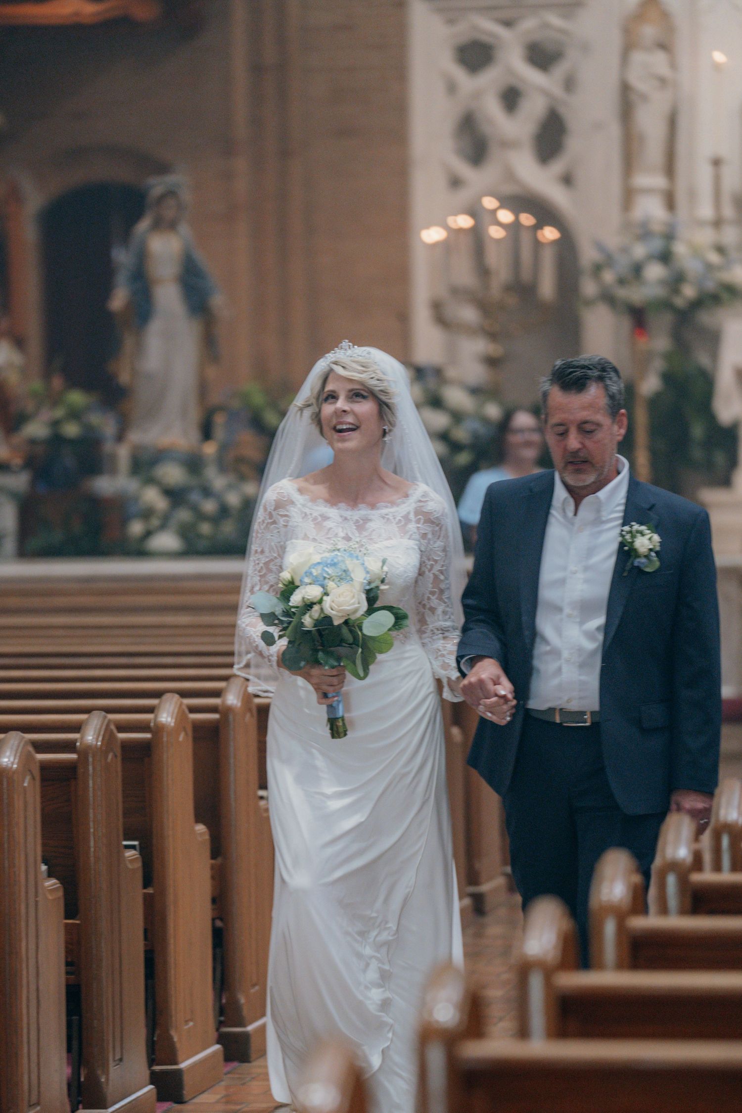 Bride and her father walking up the aisle of a Catholic church