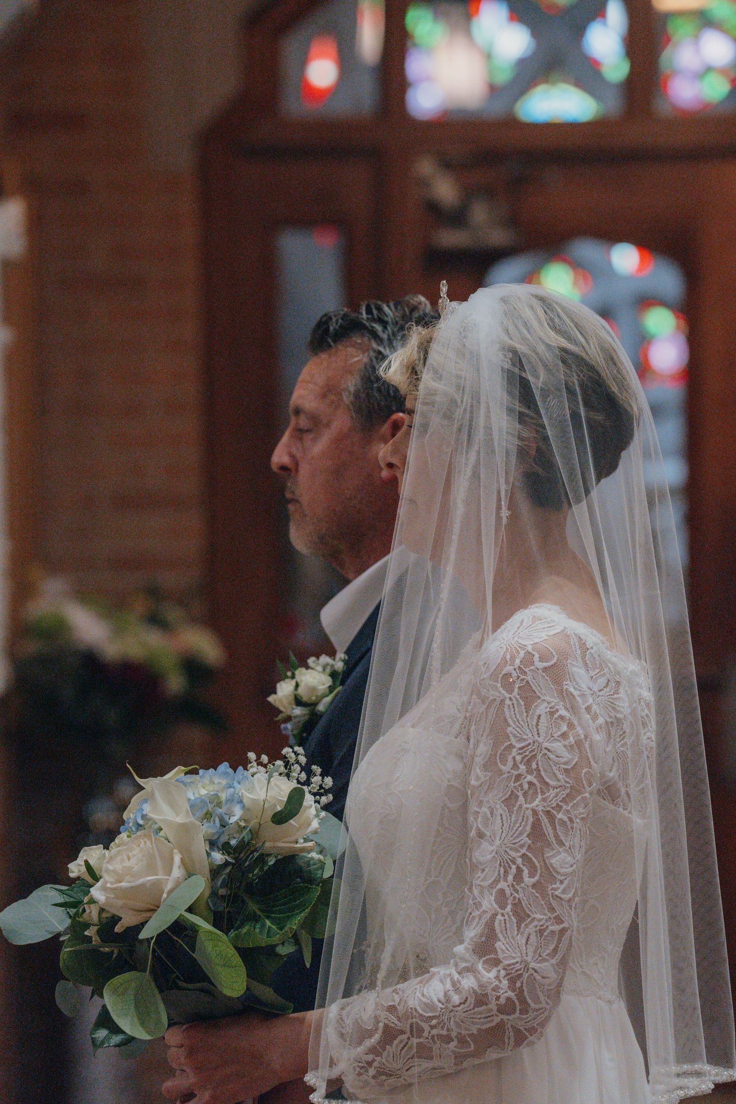Bride and her father waiting to enter the church, bouquet in hand