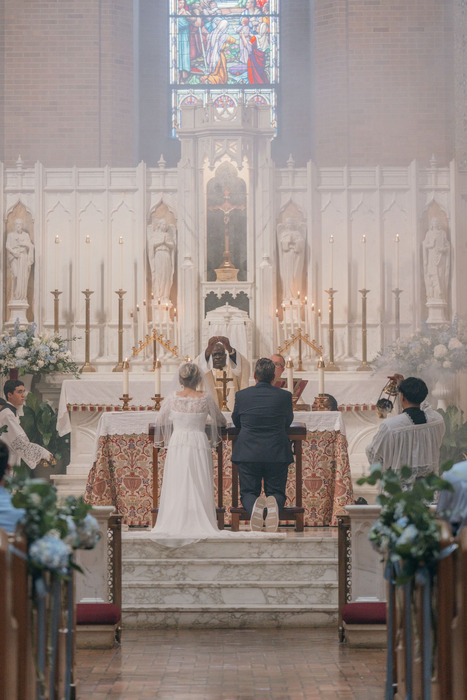 Nuptial Mass in a historic Catholic church with pews lined with flowers