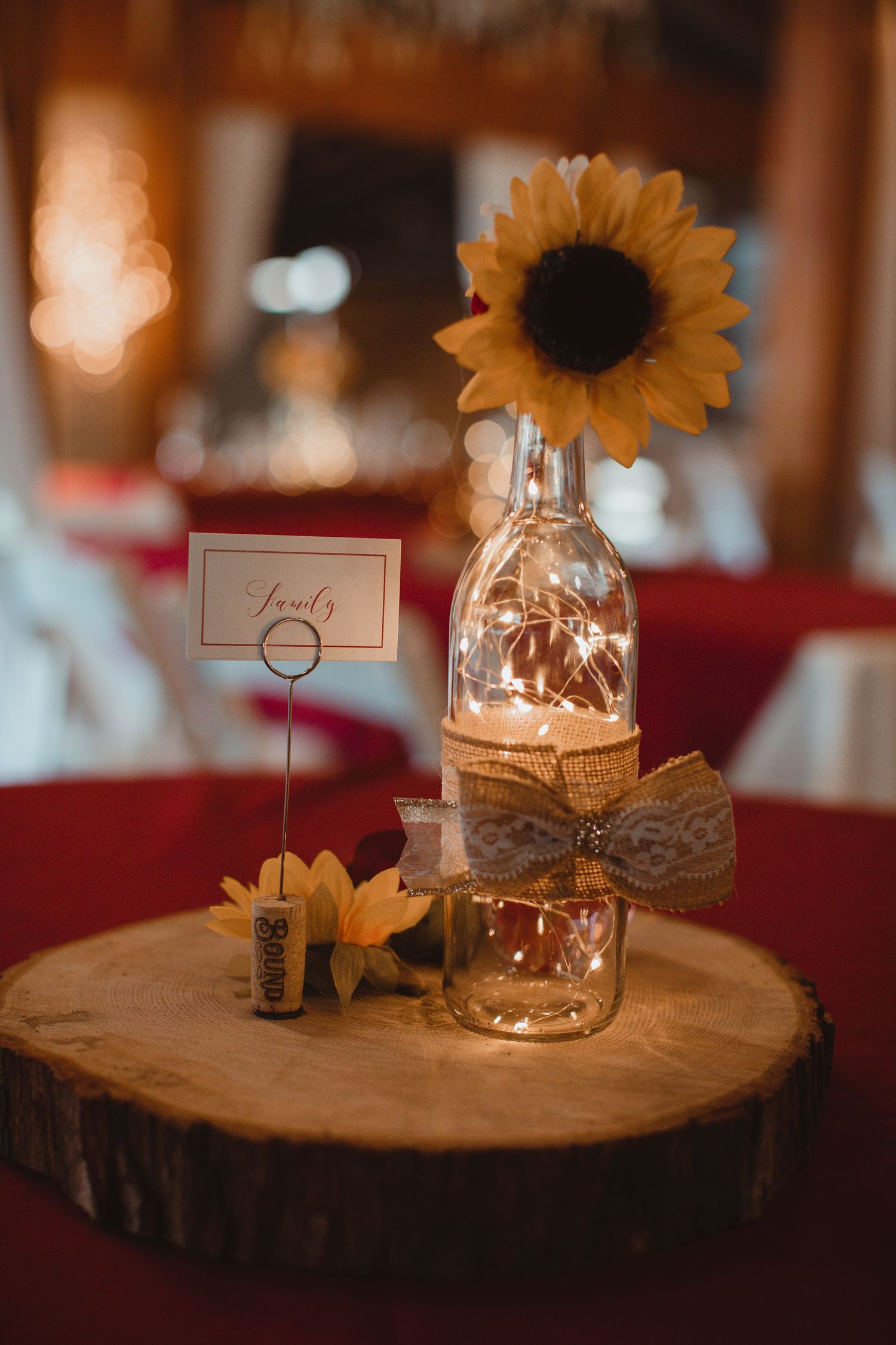 Sunflower and candle centerpiece on a wood slice at a fall barn wedding