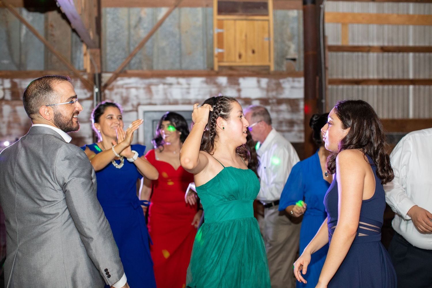 Guests cheering and dancing at a barn wedding reception