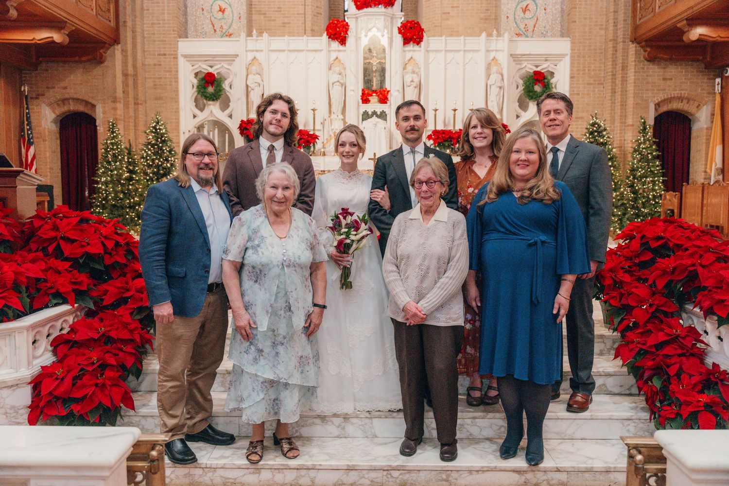 Family portrait at the altar surrounded by red poinsettias