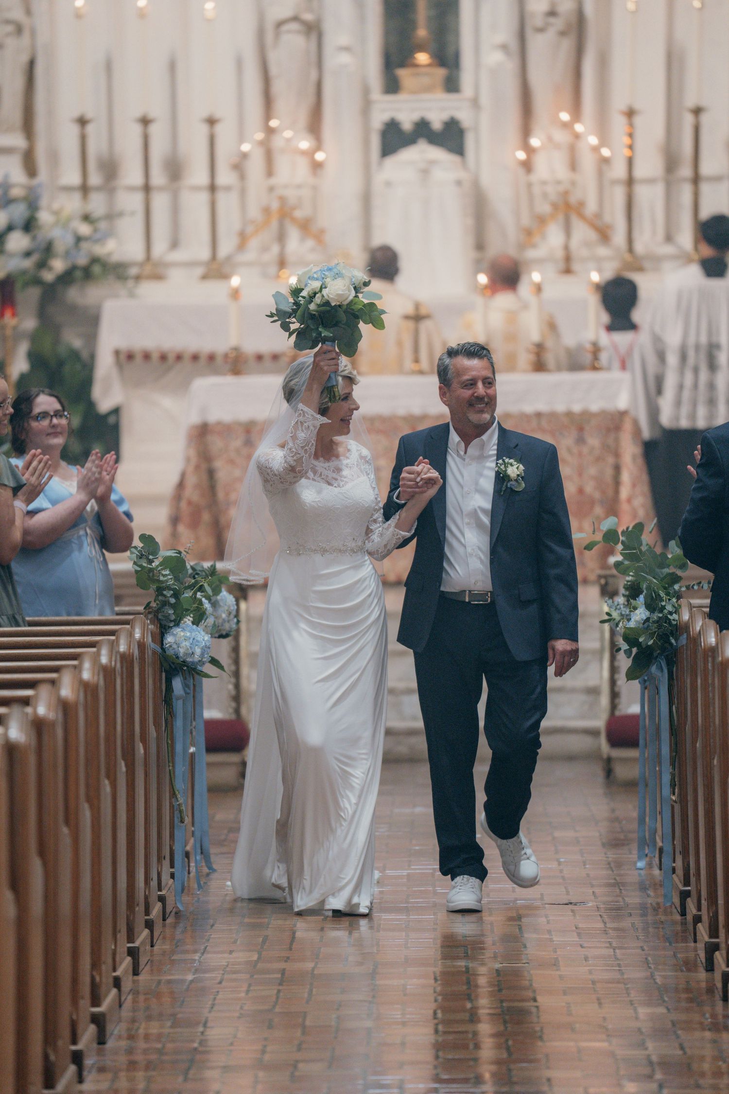 Bride and groom recessing down the aisle as guests celebrate