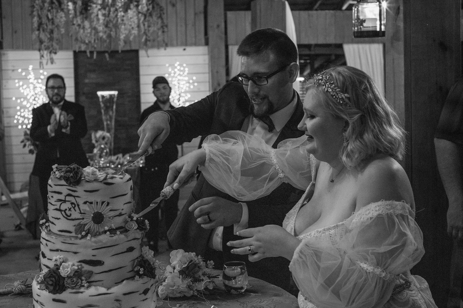 Black and white photo of the couple feeding each other wedding cake