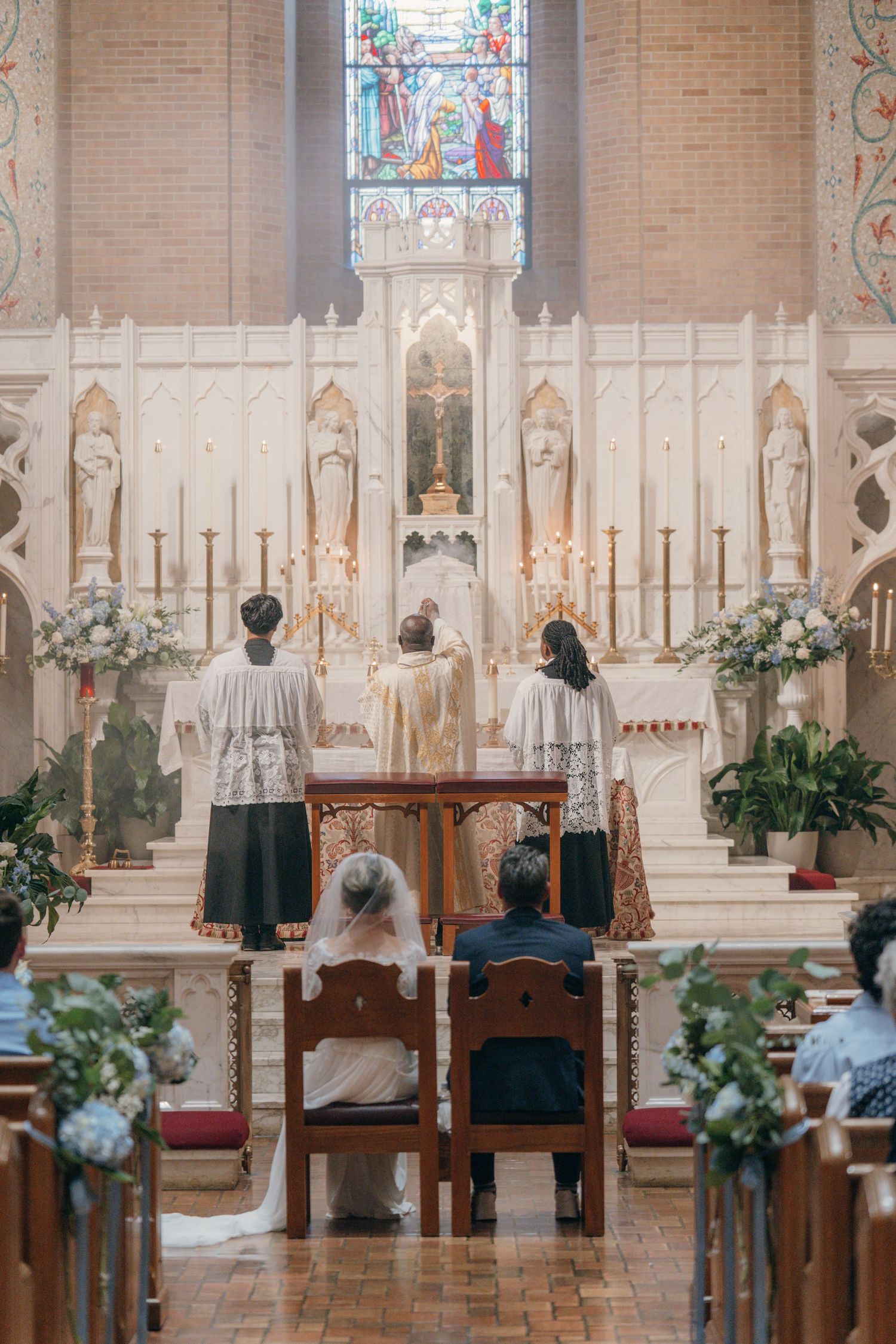 Couple kneeling before the high altar as the priest celebrates the wedding Mass