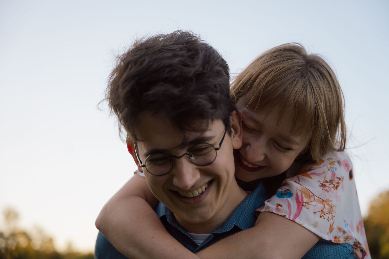 Woman hugging her fiancé from behind as they laugh during an engagement session