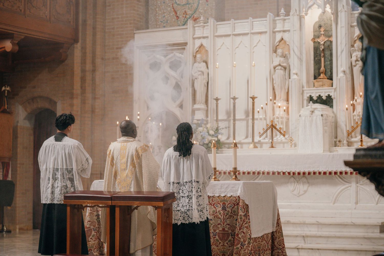 Altar servers and priest at the high altar during a Catholic wedding