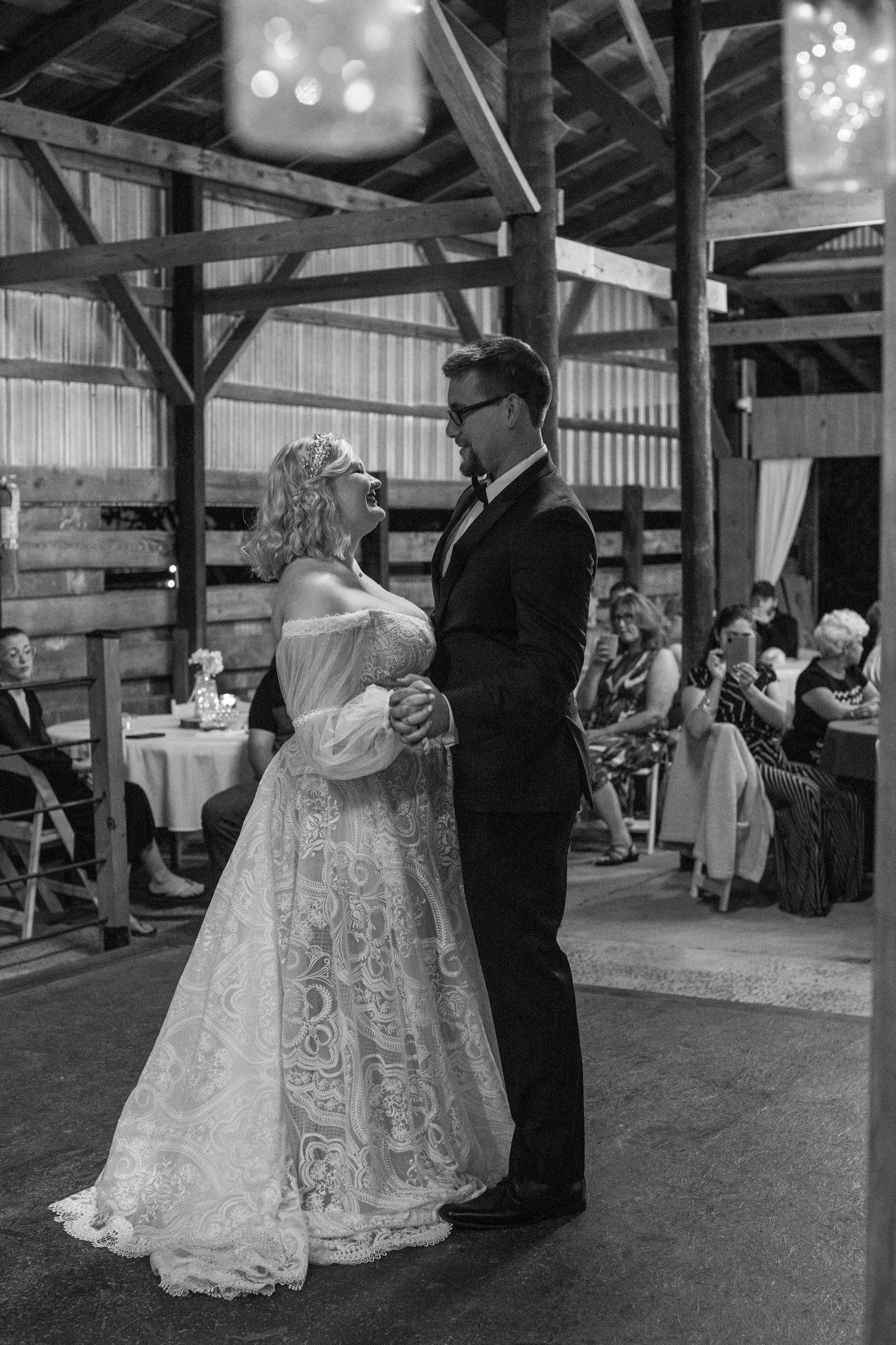 Black and white photo of the bride and groom's first dance in a barn