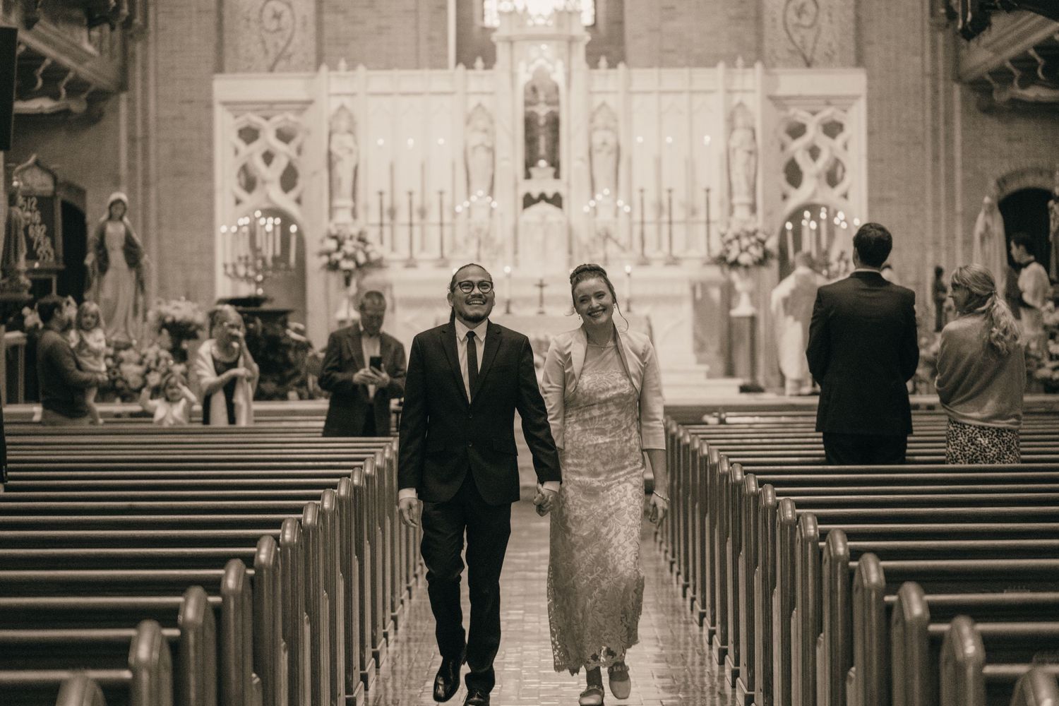 Black and white photo of a wedding procession in a Catholic church
