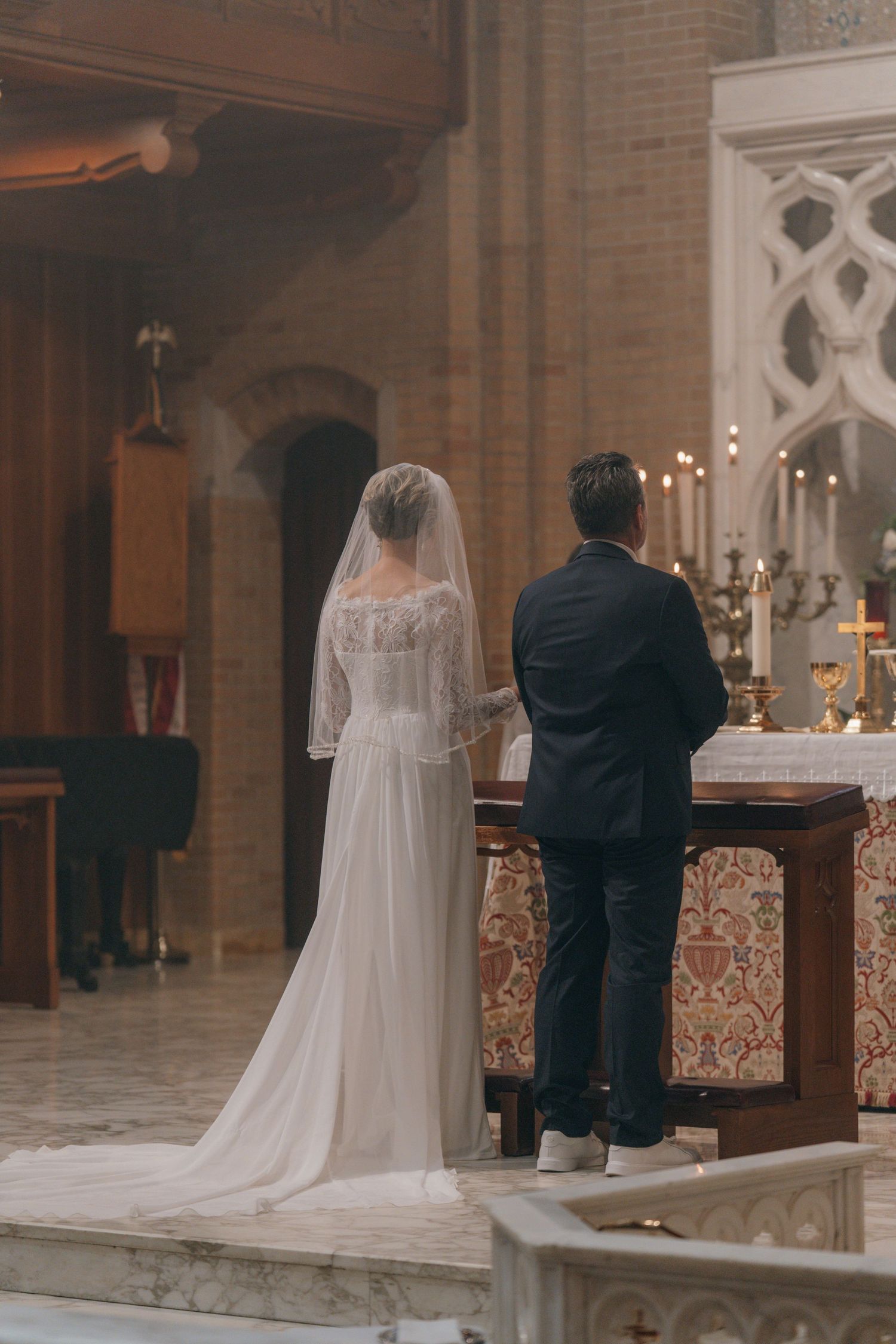 Bride and groom standing at the altar of a Gothic Revival church