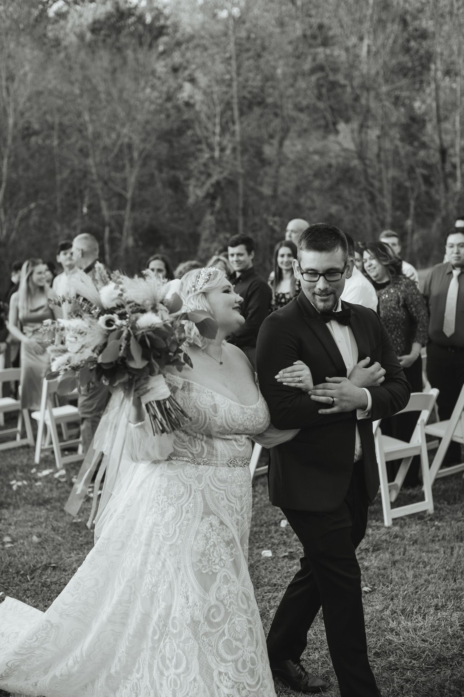 Black and white photo of the bride being escorted down the aisle