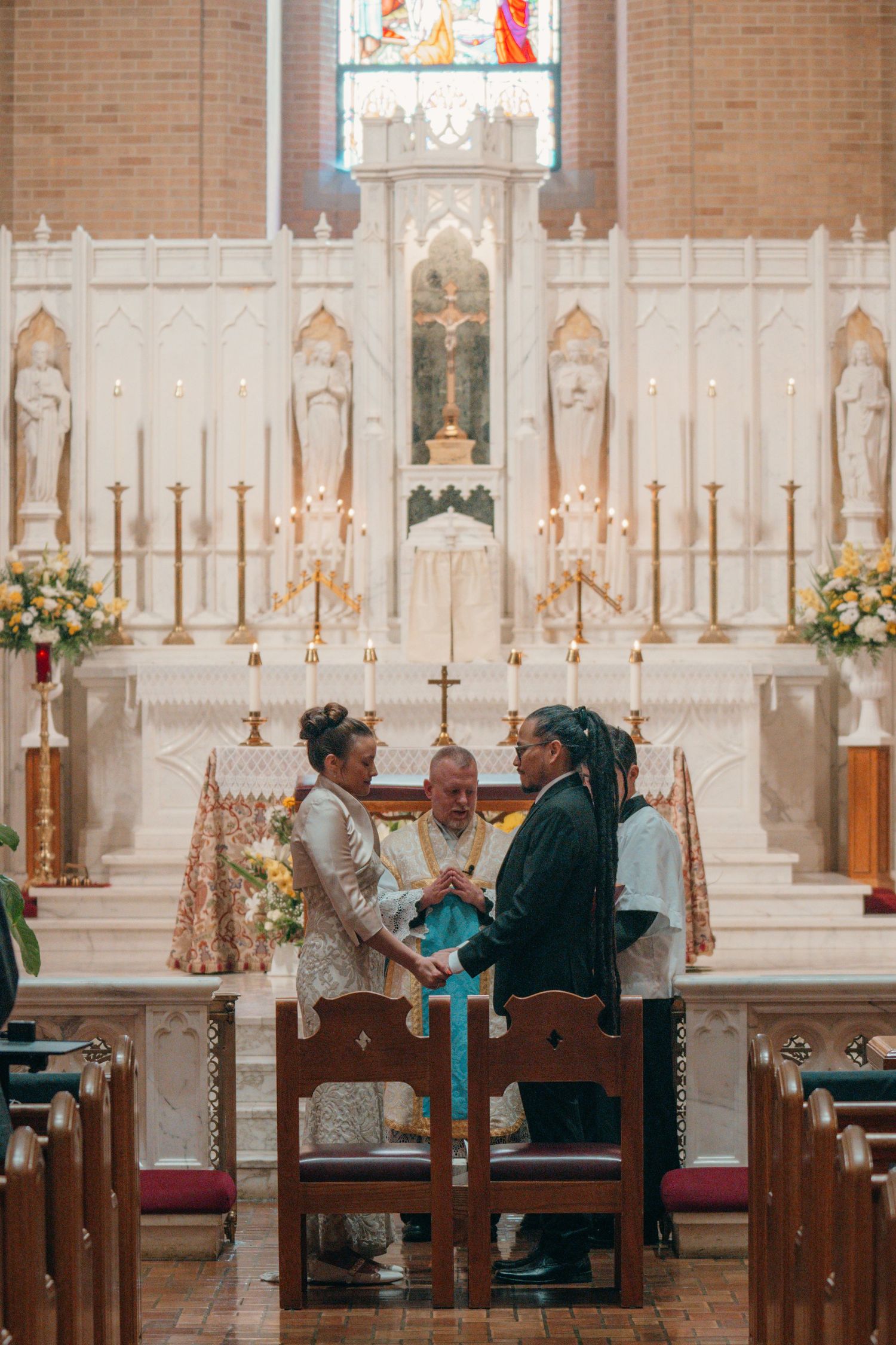Bride and groom kneeling at the high altar during a Catholic wedding