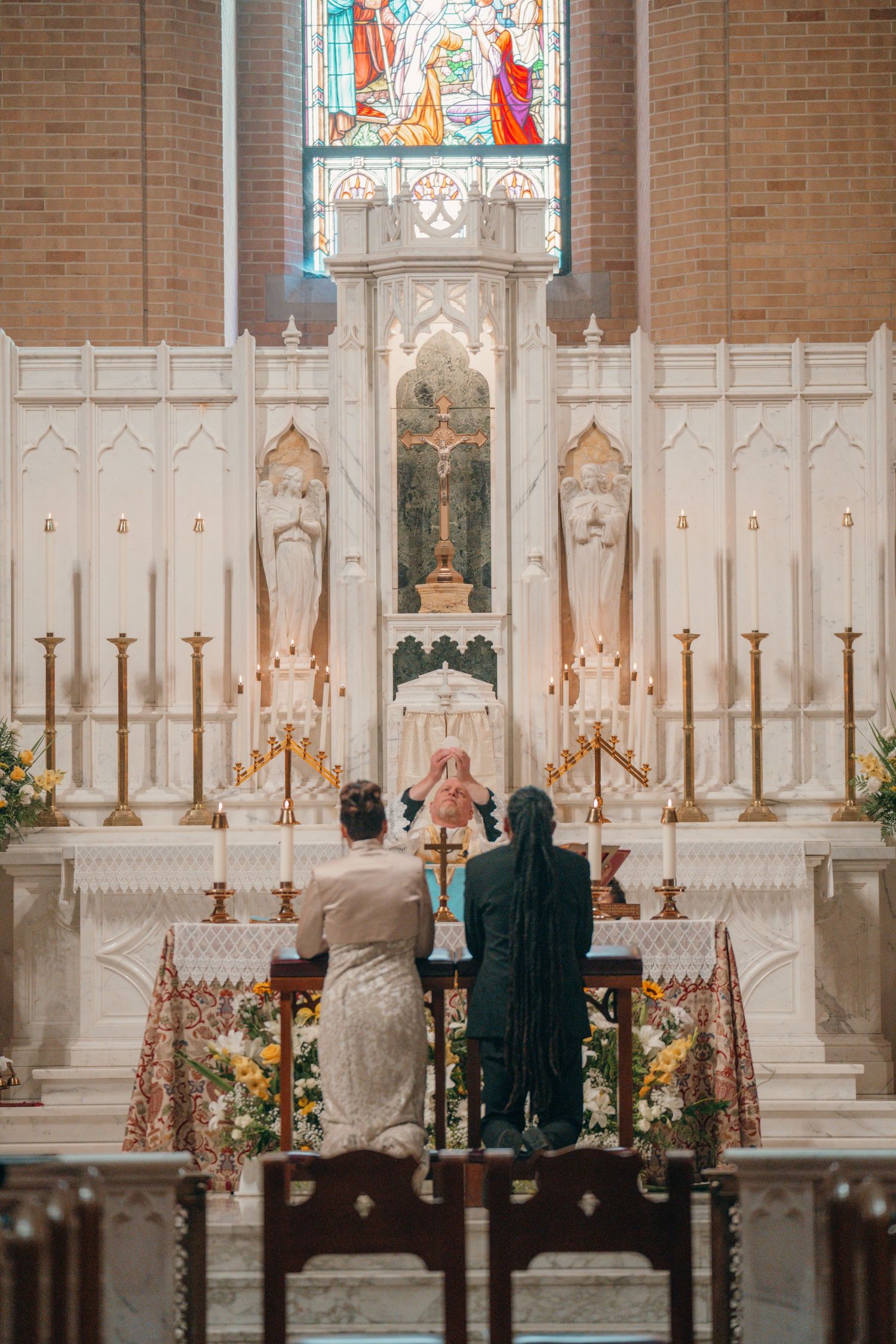 Bride and groom standing at the high altar during their Catholic wedding Mass