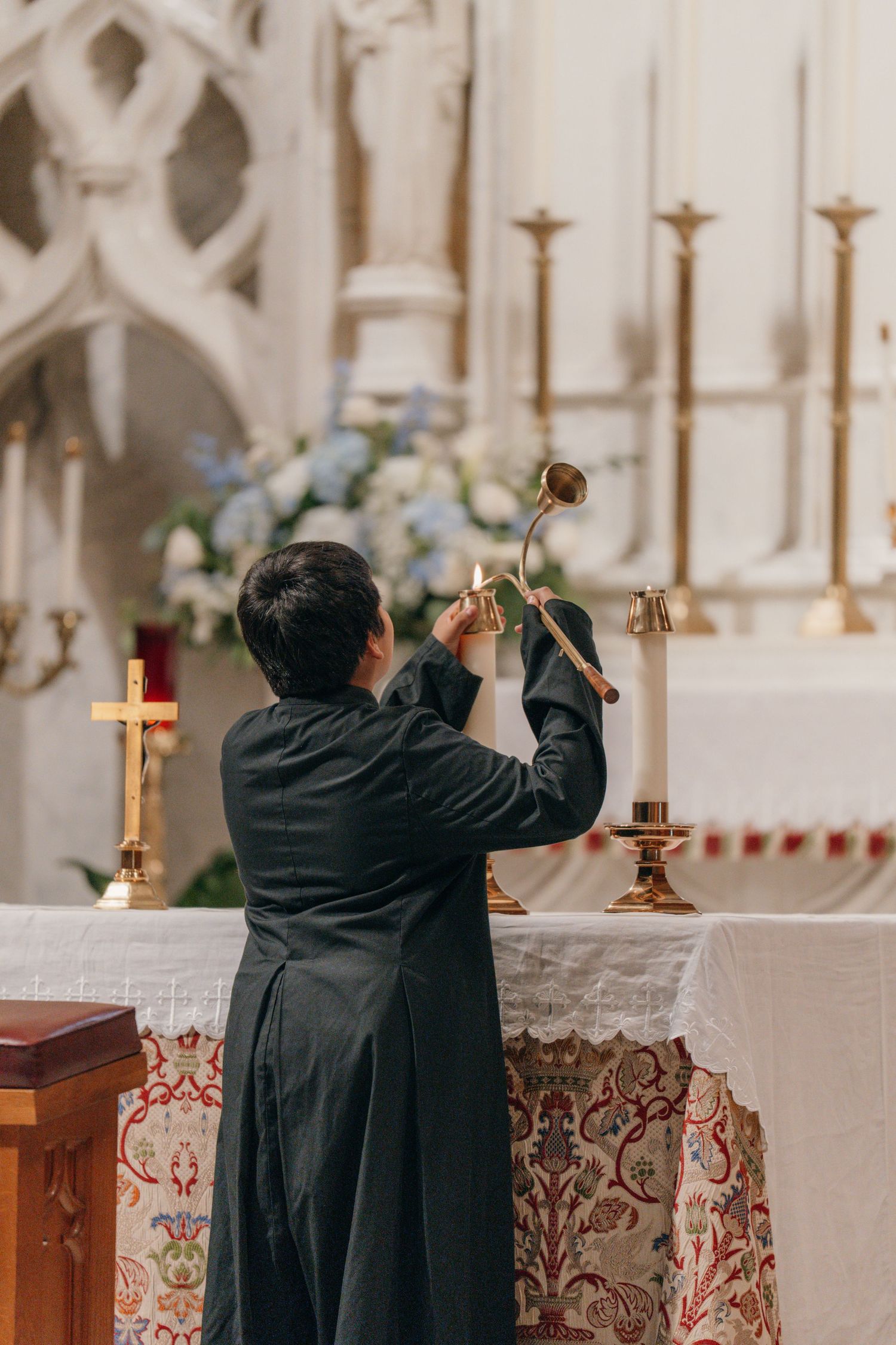 Wedding florist arranging flowers on the high altar before the ceremony