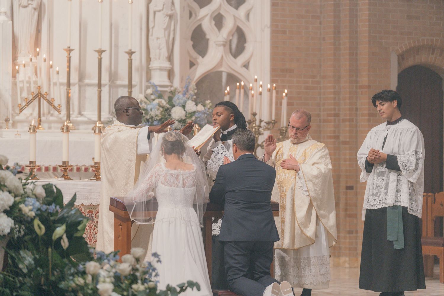 Priest and altar servers with the bride and groom during the wedding liturgy