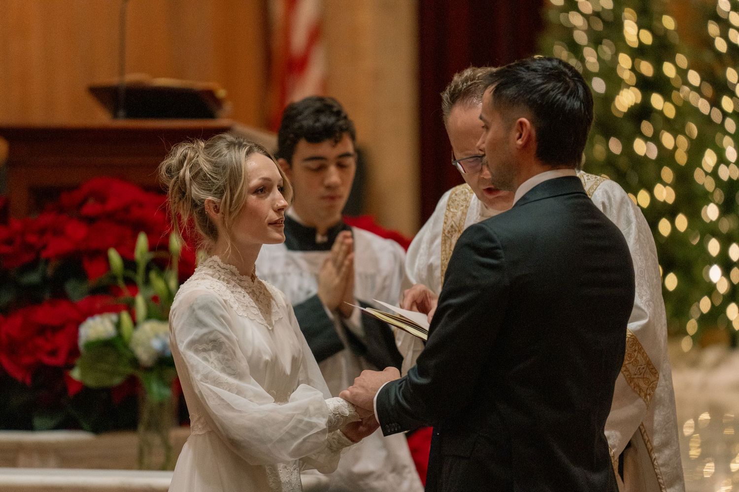 Groom placing the ring on the bride's finger during a Christmas wedding Mass