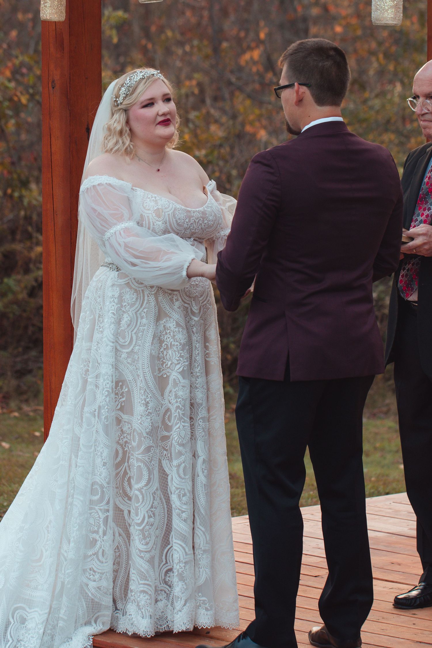 Bride holding the groom's hands while exchanging vows outdoors