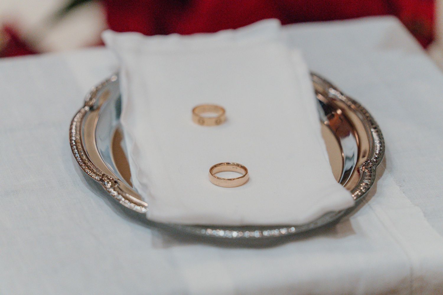 Two wedding rings on a silver tray at a Catholic wedding