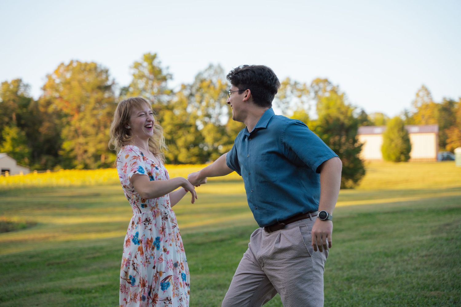 Couple twirling in an open field during their engagement photos