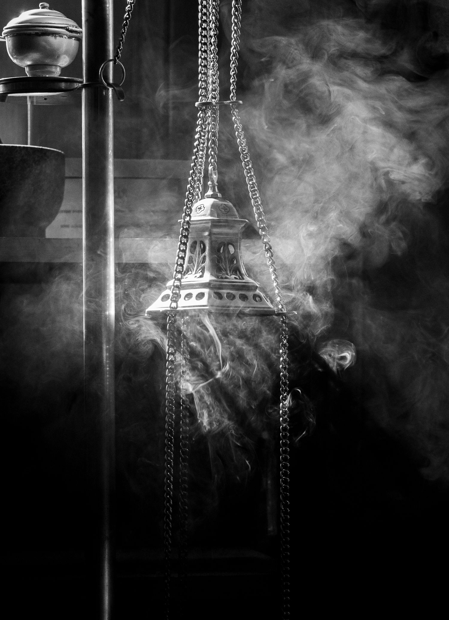 Black and white photo of incense smoke rising from a thurible