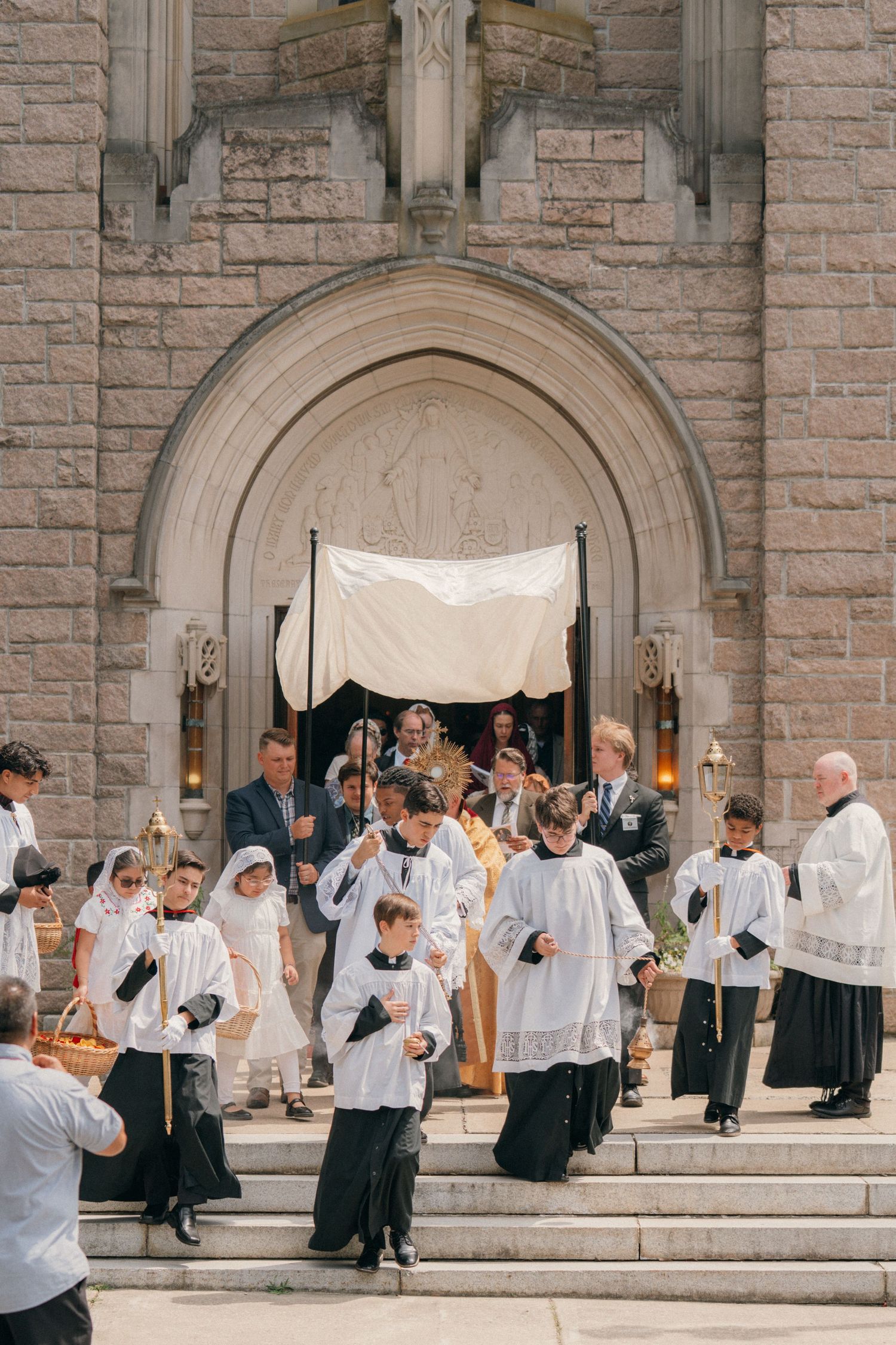 Benediction on the steps of a Gothic stone church at the close of a Corpus Christi procession