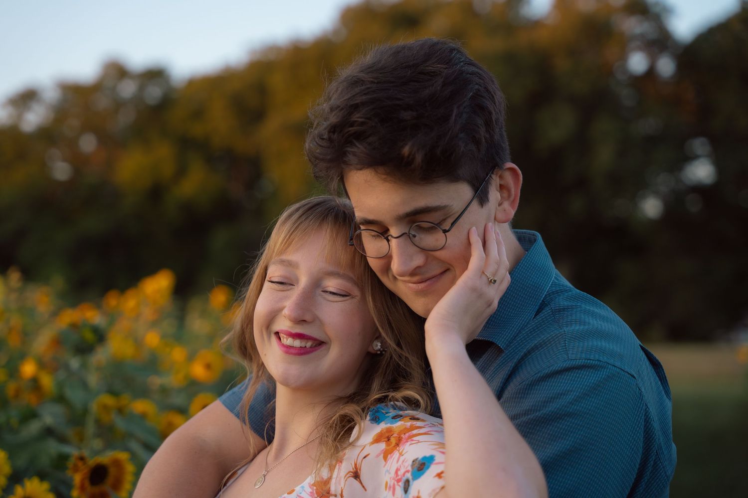 Couple embracing in a sunflower field at golden hour