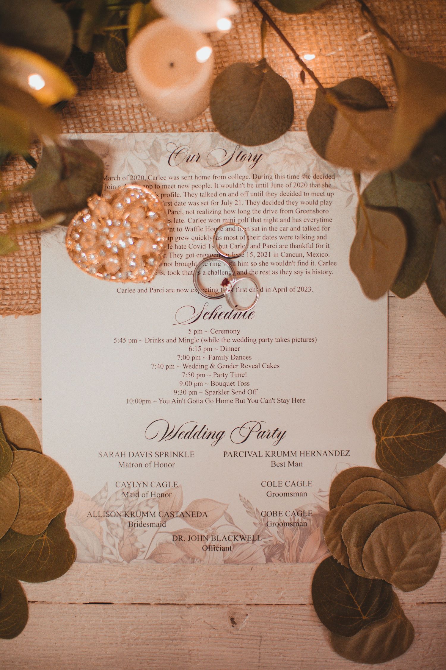 Wedding invitation suite surrounded by eucalyptus and candlelight