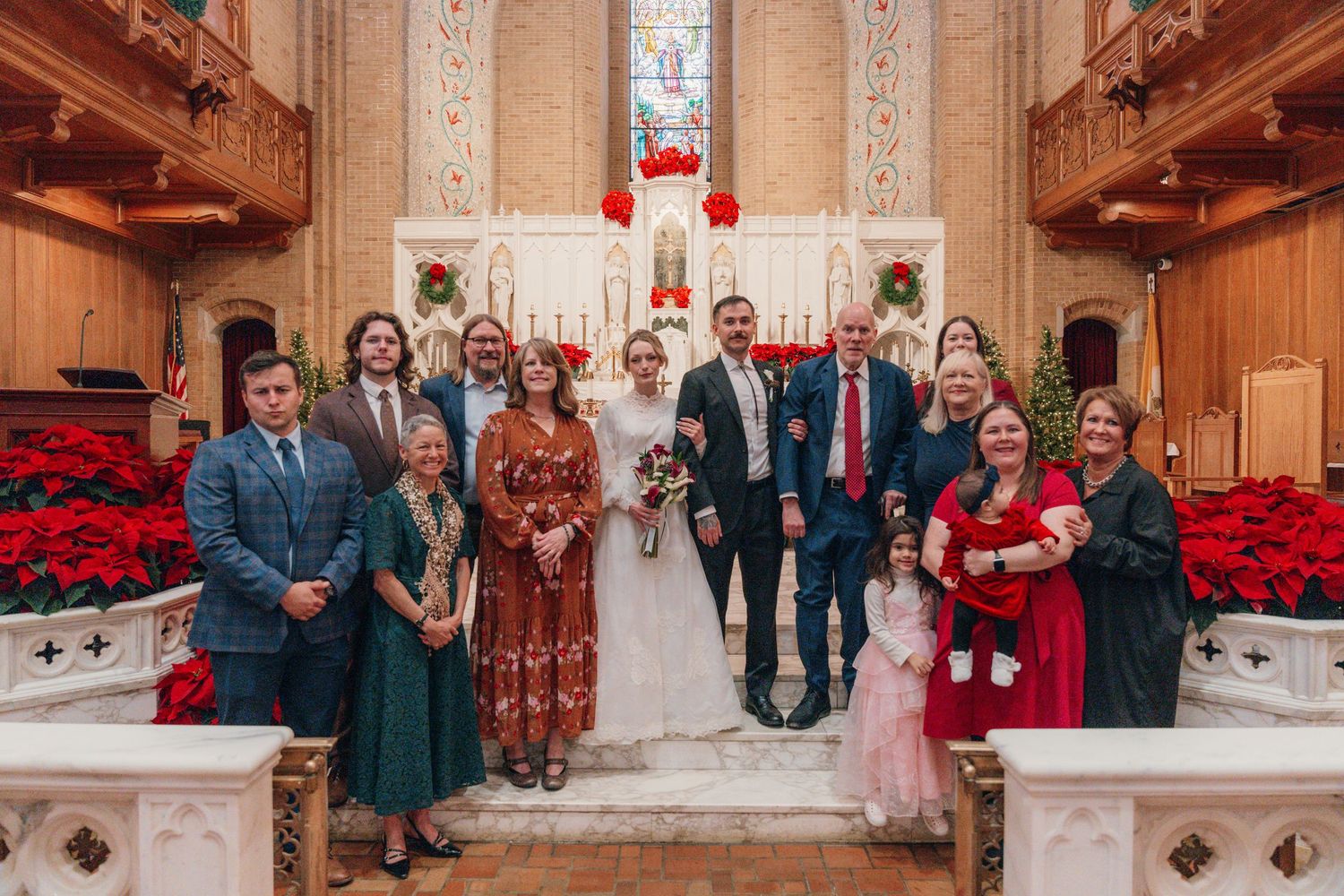 Large family group photo at the altar after a Christmas season wedding