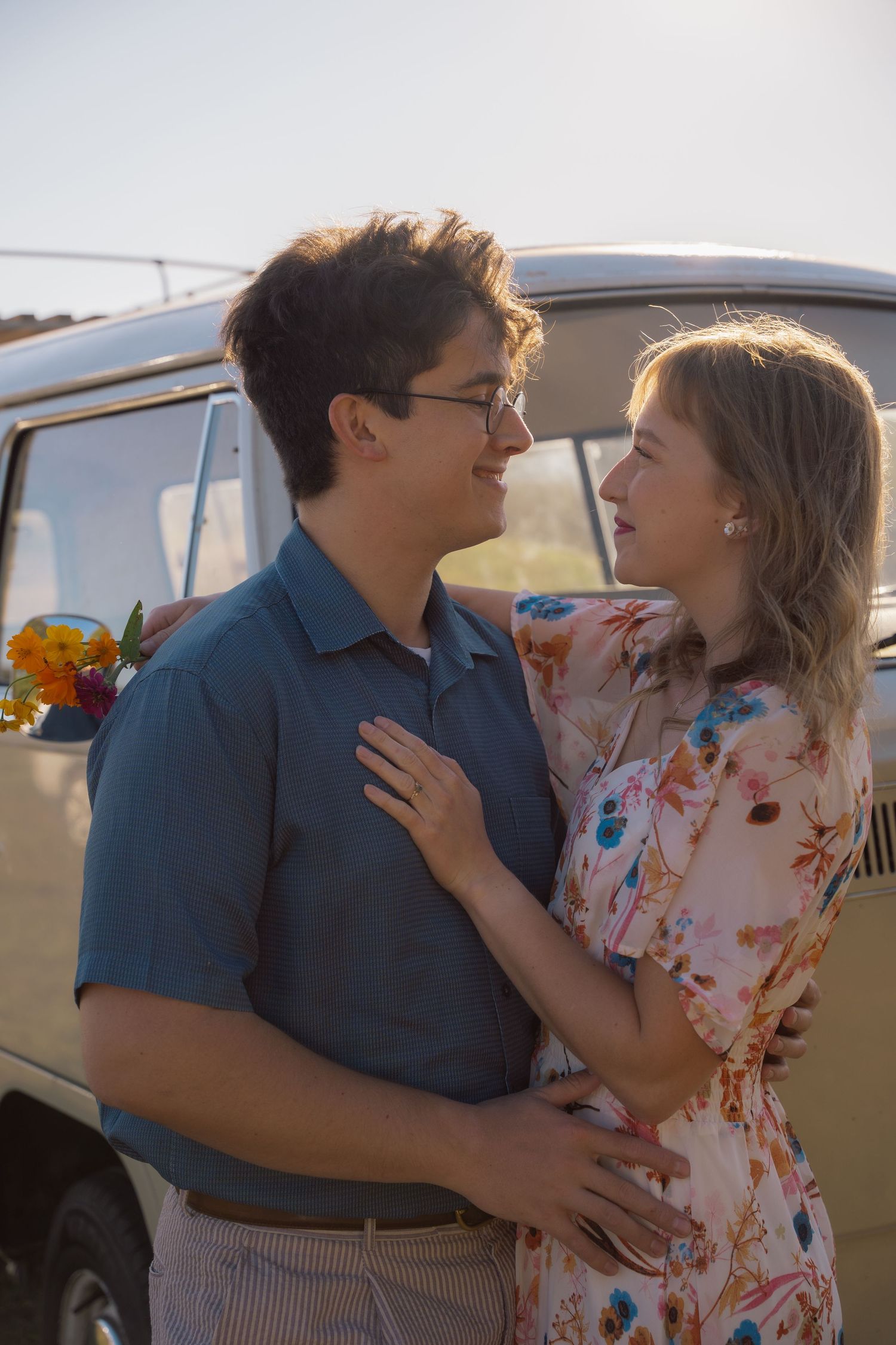 Couple embracing beside a vintage van during their engagement session