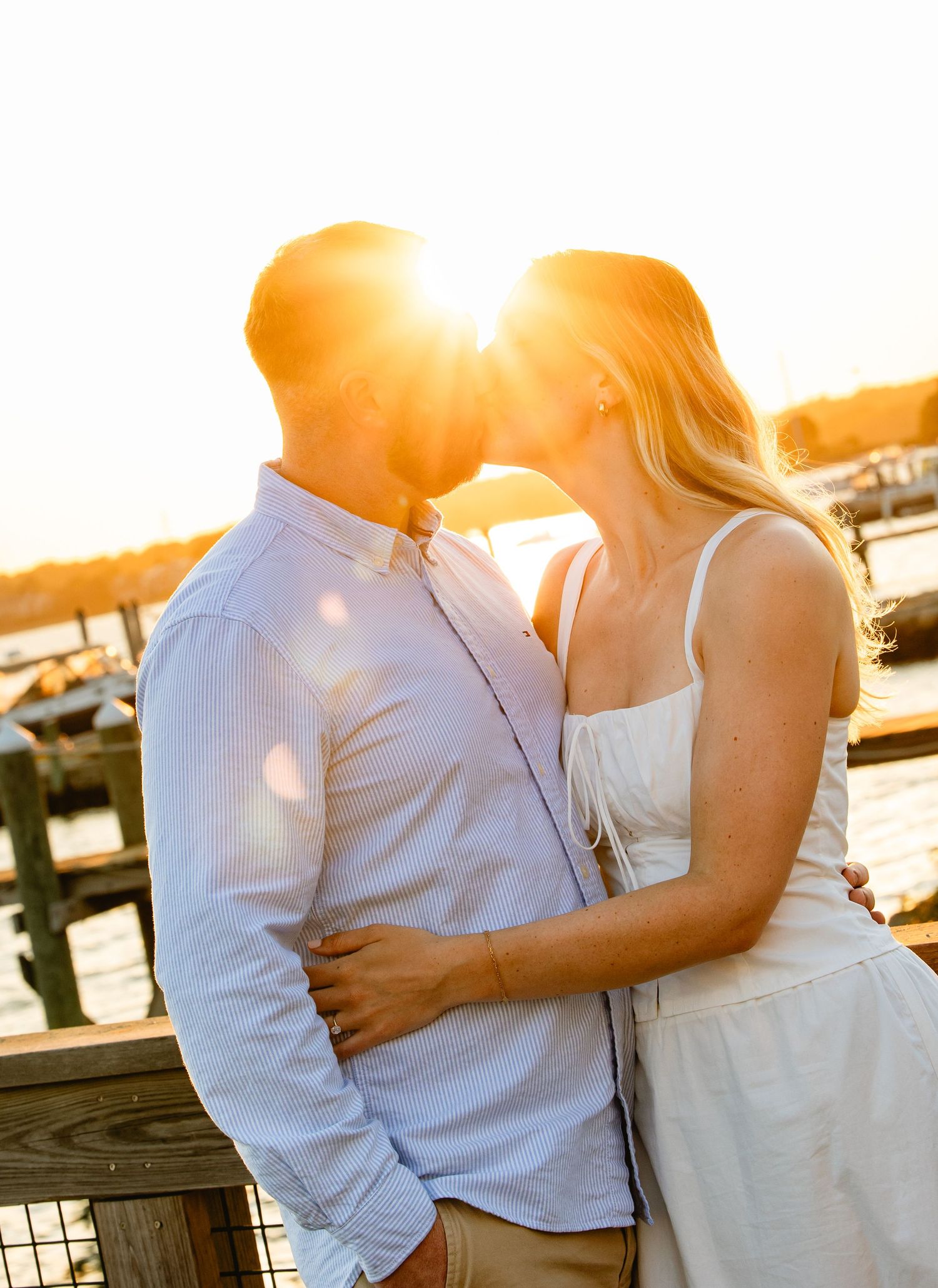 A romantic sunset moment captured in a series of intimate poses along a waterfront. New England engagement photos.