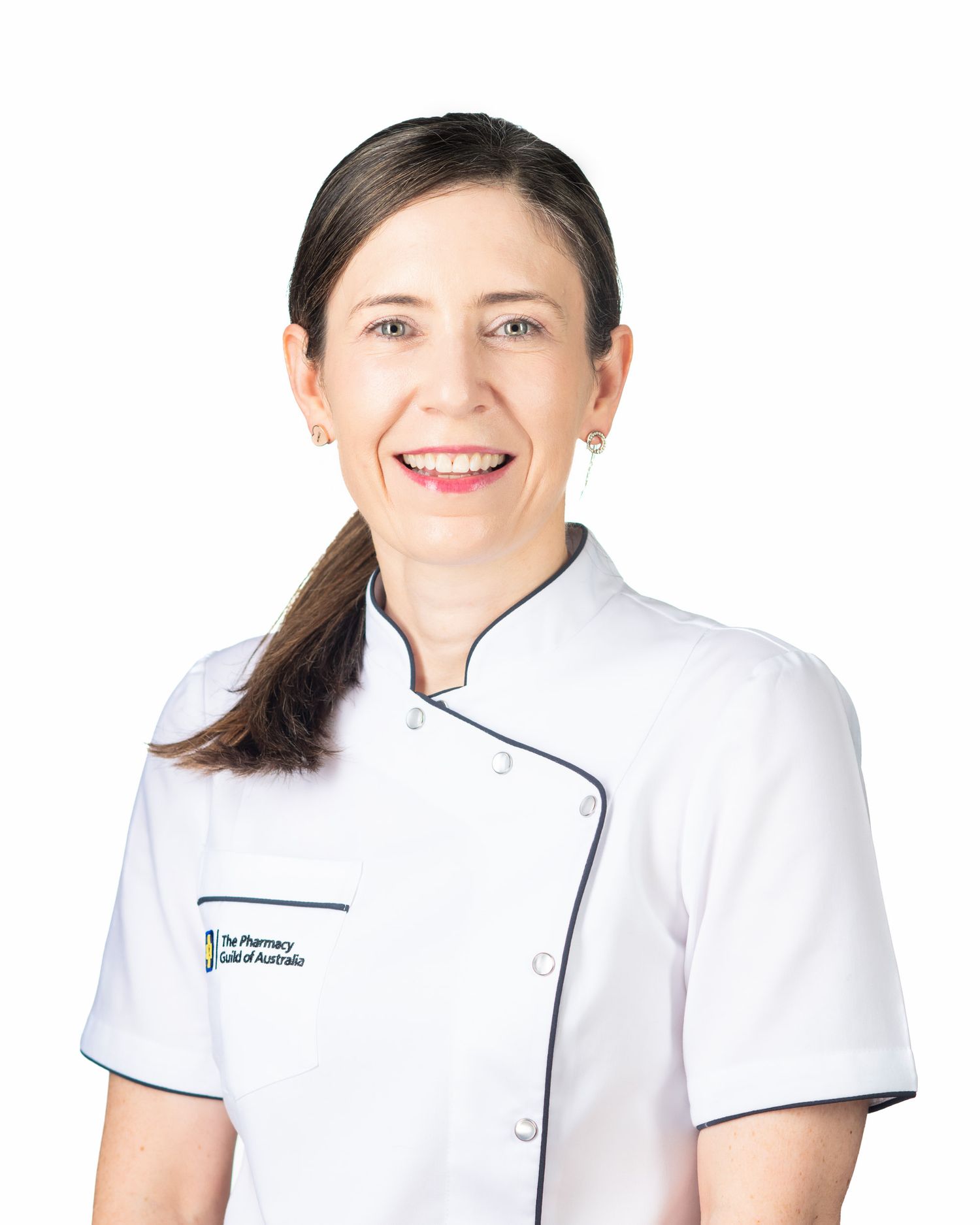 Smiling woman in white Pharmacy Guild of Australia uniform, professional healthcare portrait.