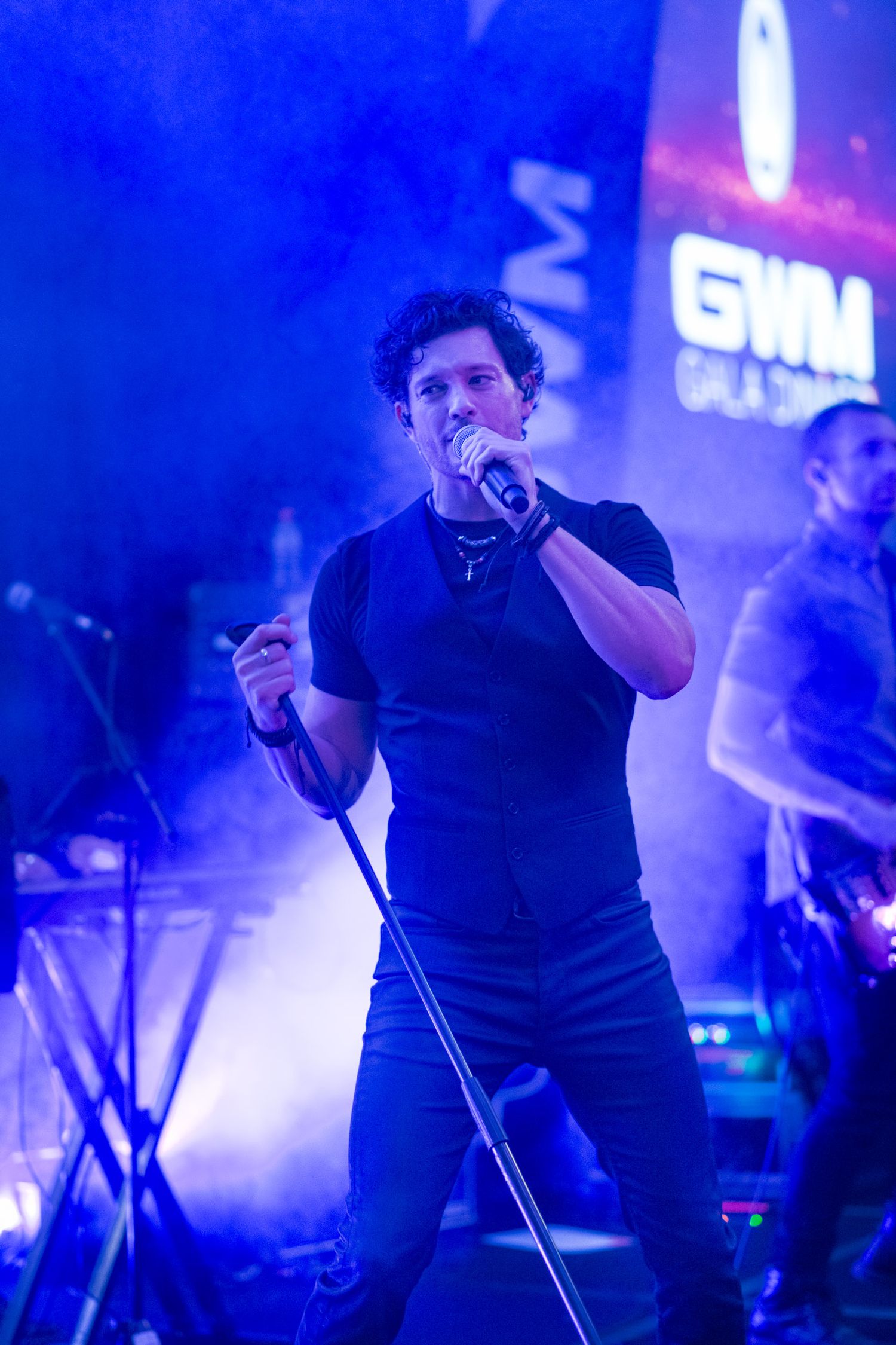 Male singer performs passionately on stage at GWM Gala dinner event.