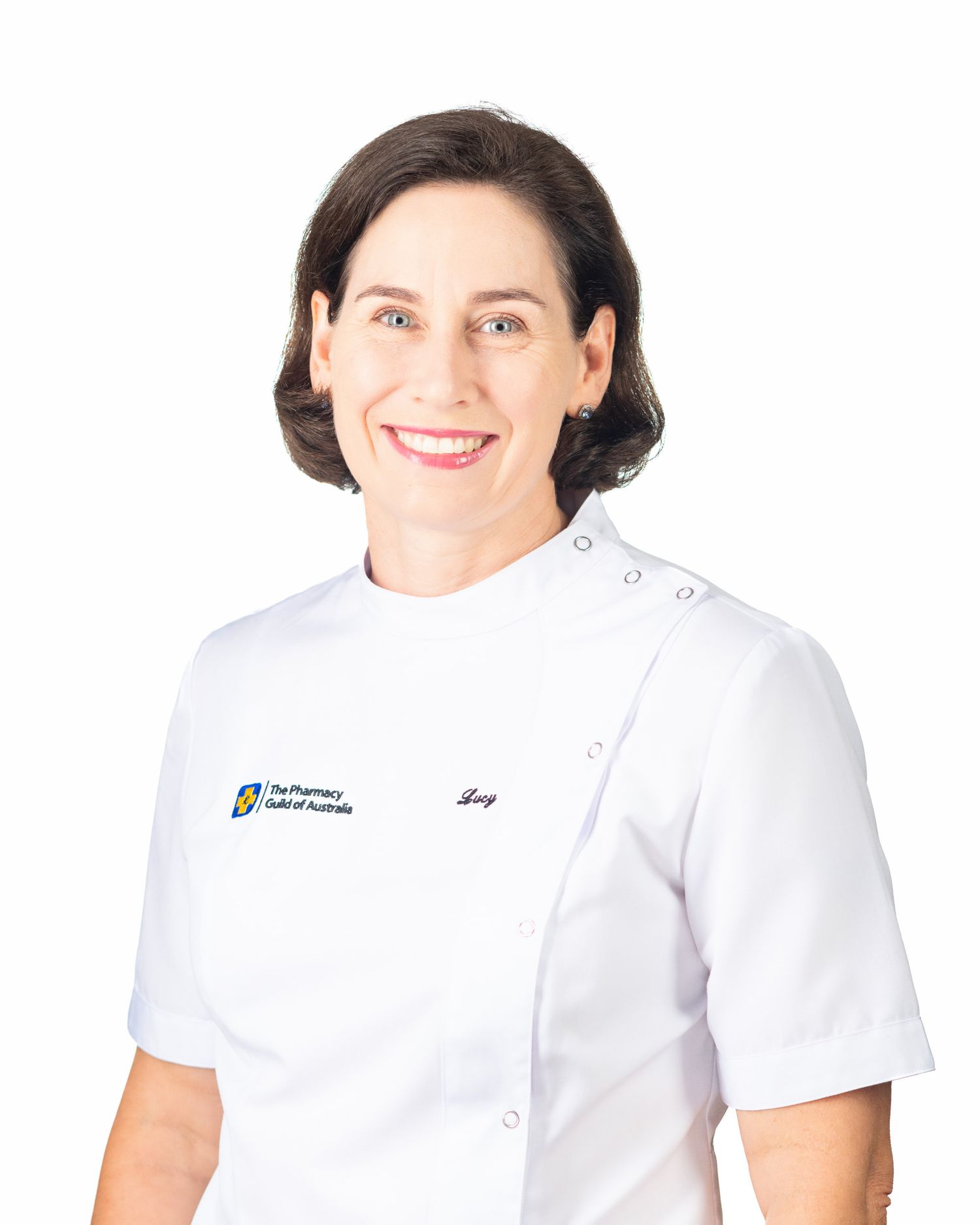 Smiling woman in white Pharmacy Guild of Australia uniform, professional healthcare headshot on white background.