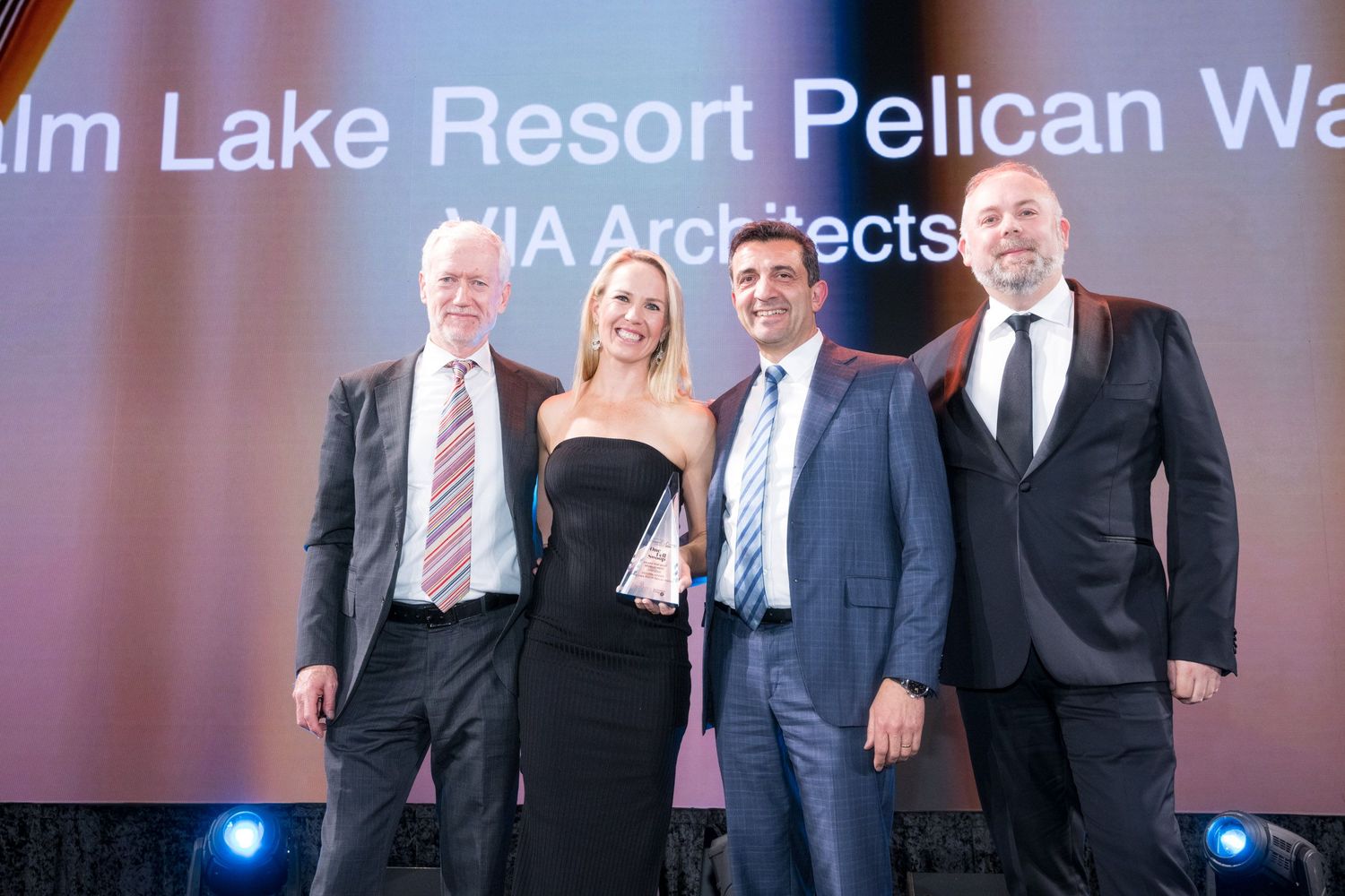 Four professionals pose together at Palm Lake Resort Pelican Waters VIA Architects award ceremony.
