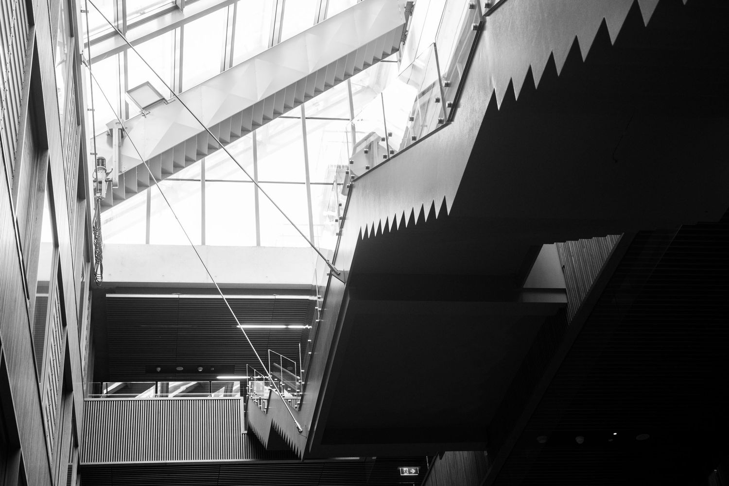 Black and white interior architectural photo showing dramatic angular steel beams and geometric shapes in a modern building.