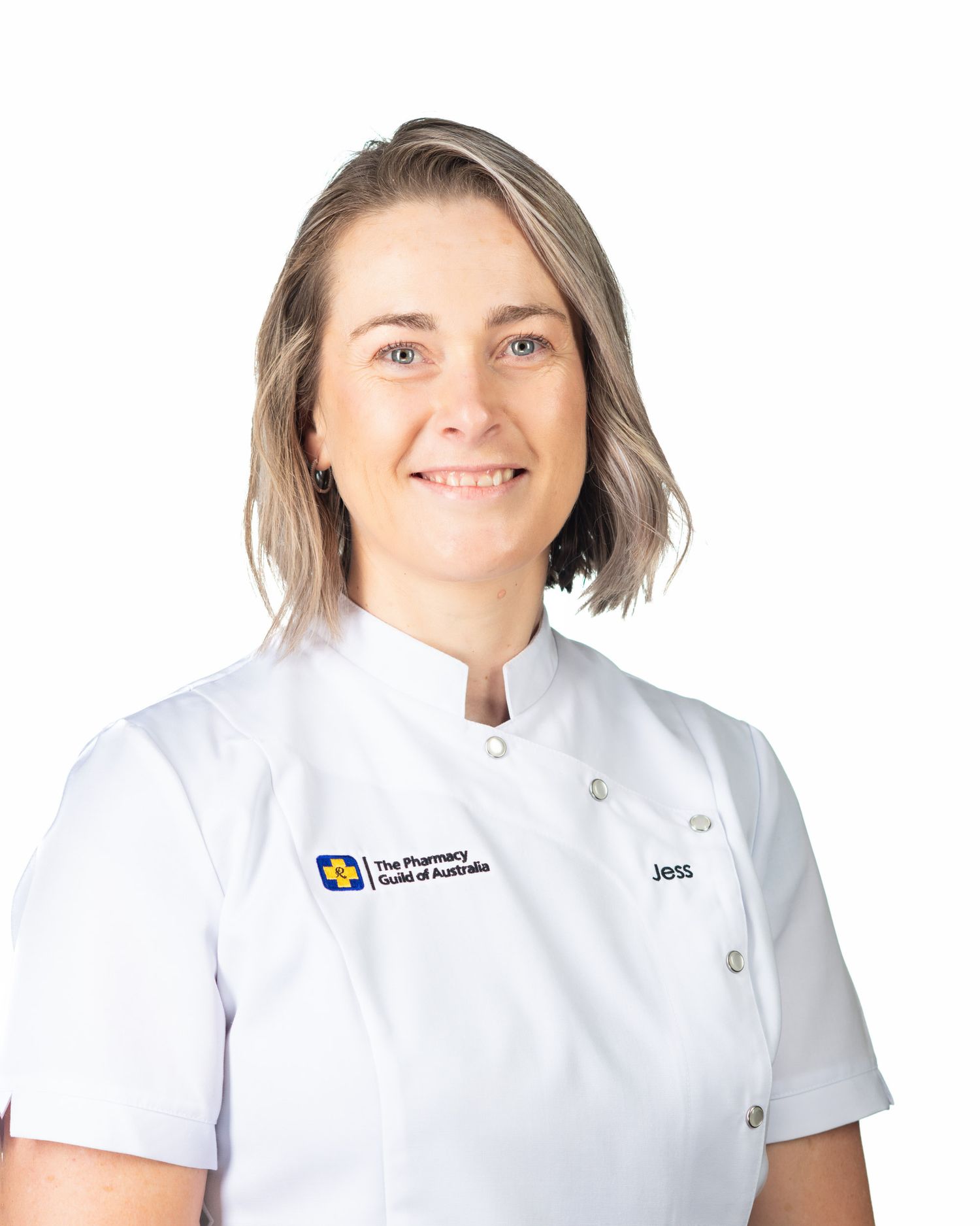 Woman named Jess in white Pharmacy Guild of Australia uniform, professional pharmacy staff headshot.
