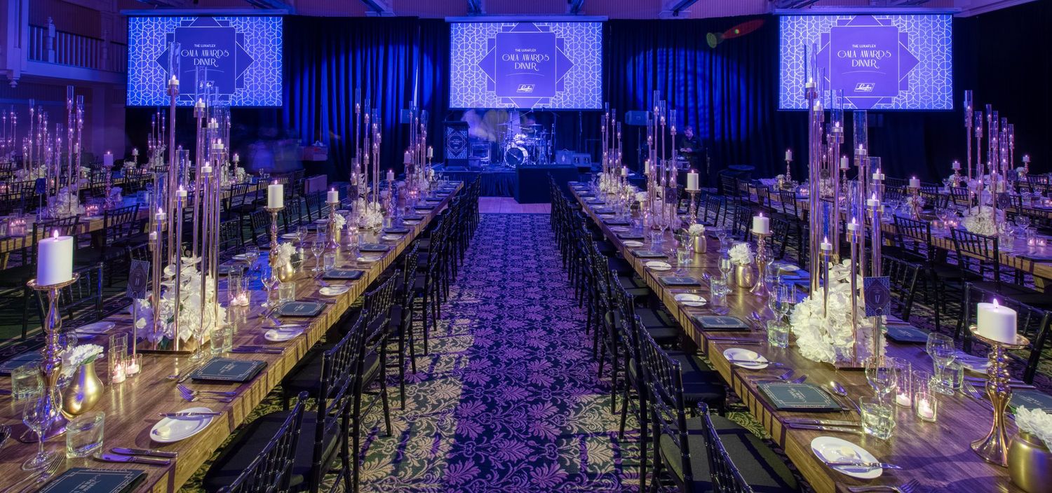 Elegant long banquet tables with crystal candelabras set for grand gala dinner event.