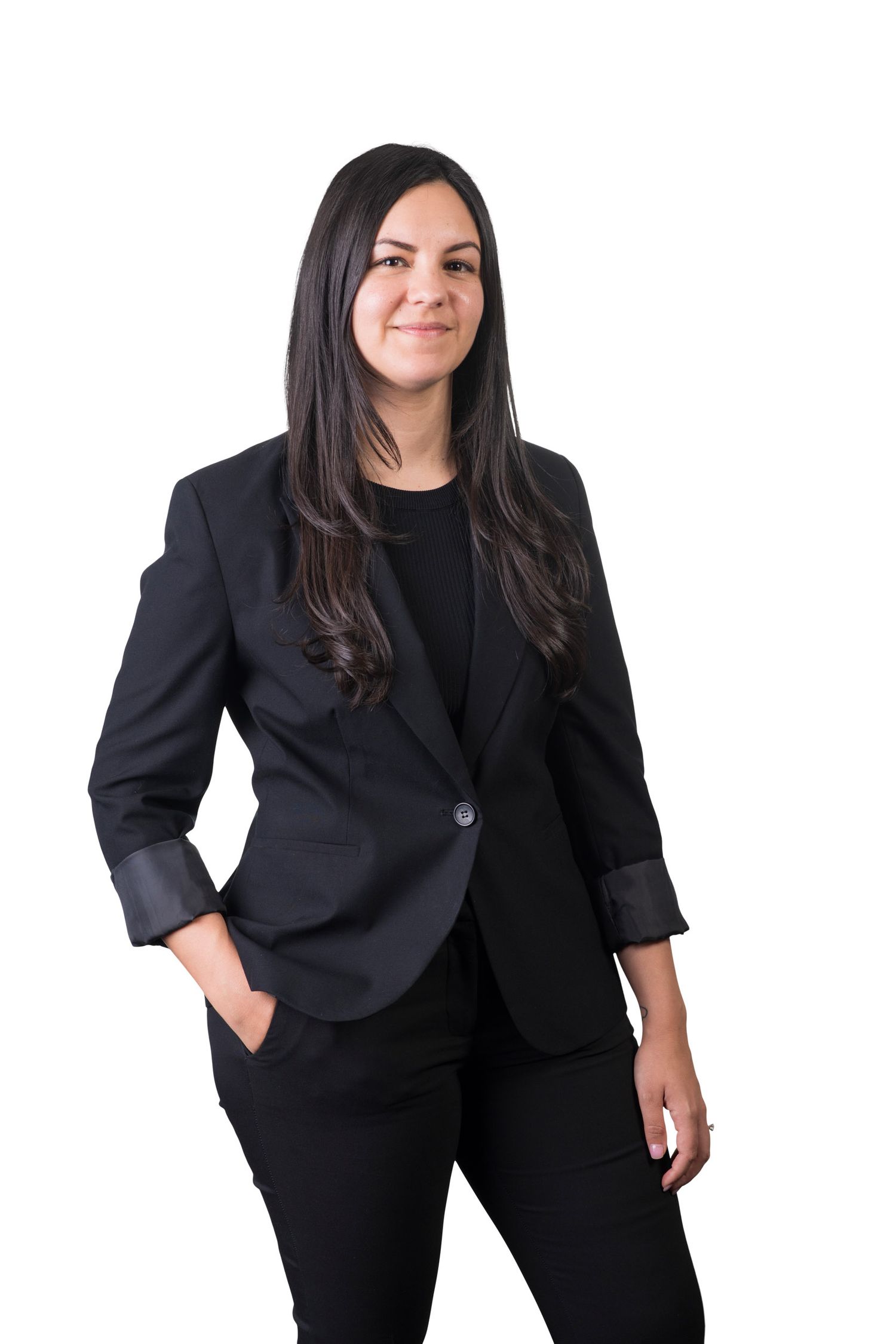 Confident woman with long dark hair wearing a black blazer poses for a professional portrait.