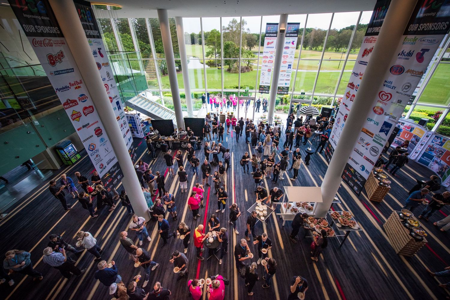 Aerial view of crowded modern convention center atrium.