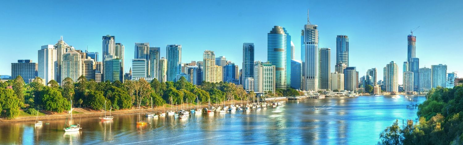 Stunning panoramic view of Brisbane CBD skyline reflecting on the Brisbane River on a bright sunny day.