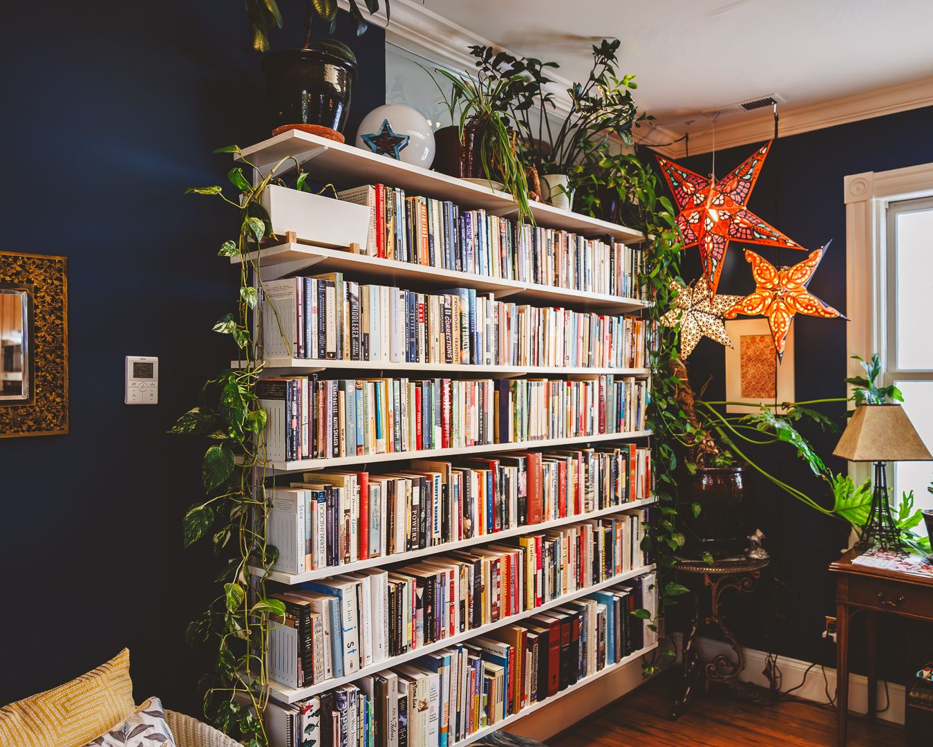 Floor-to-ceiling bookshelf filled with books in a historic home interior